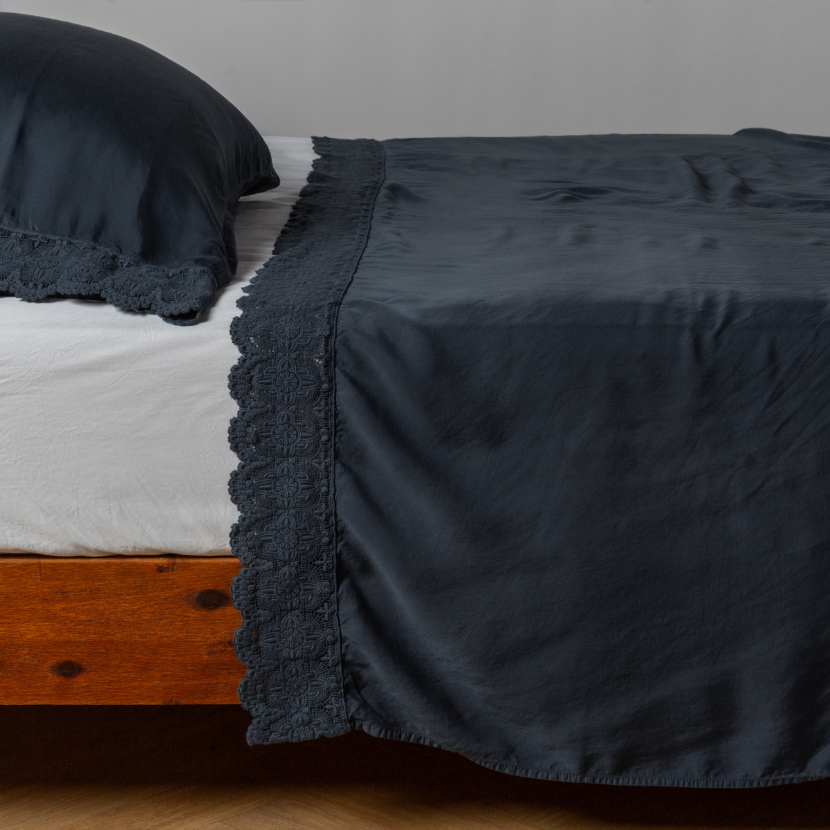 matching cotton lace trimmed flat sheet and pillowcase shown with simple white sheet - side view.