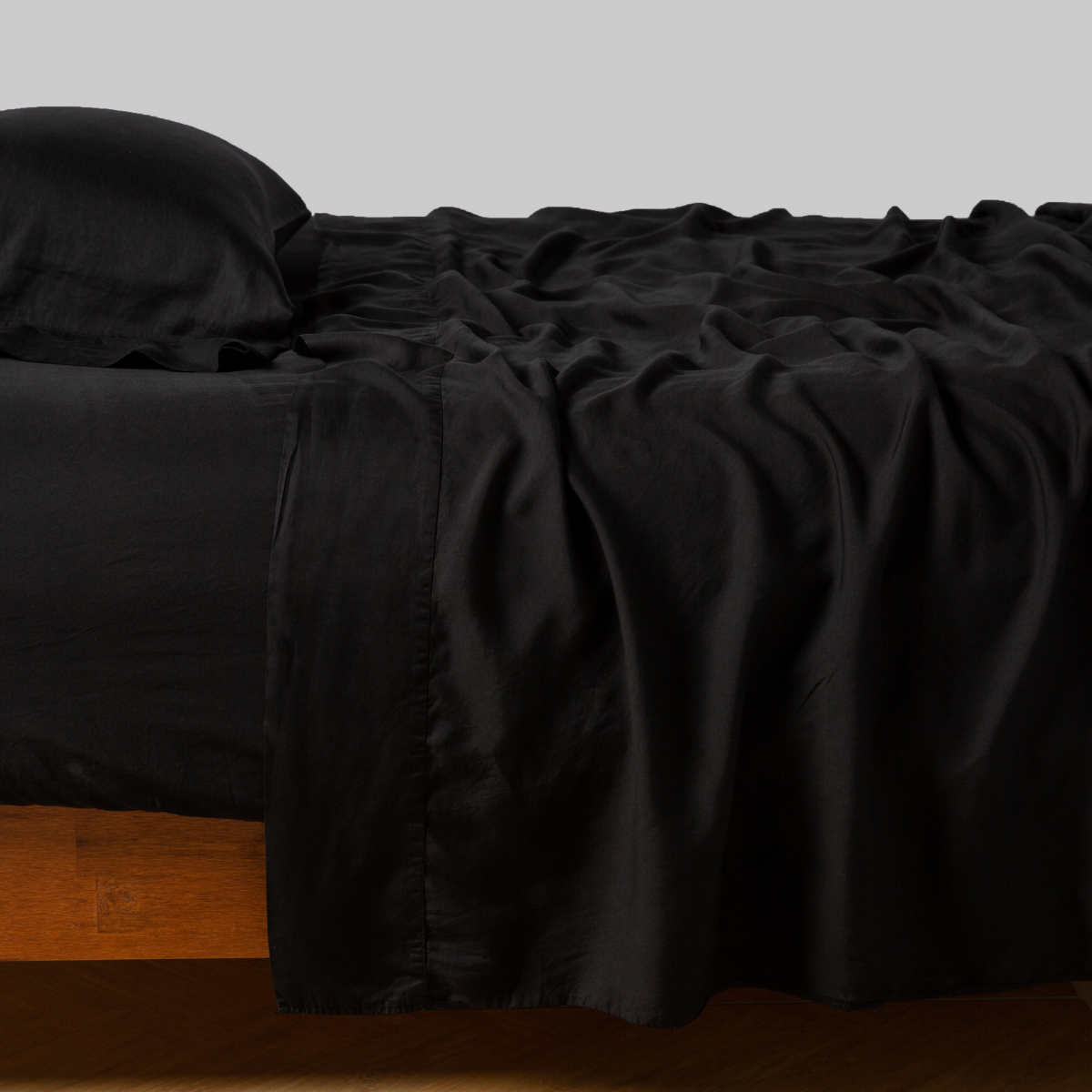 Corvino:  sleeping pillow with matching rumpled sheeting - side view.
