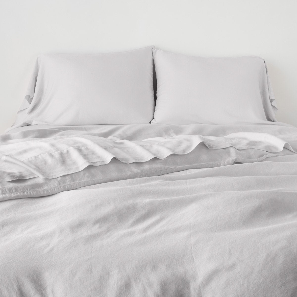 Sterling: duvet cover with matching sleeping pillows and sheeting against a white wall - end of bed view.