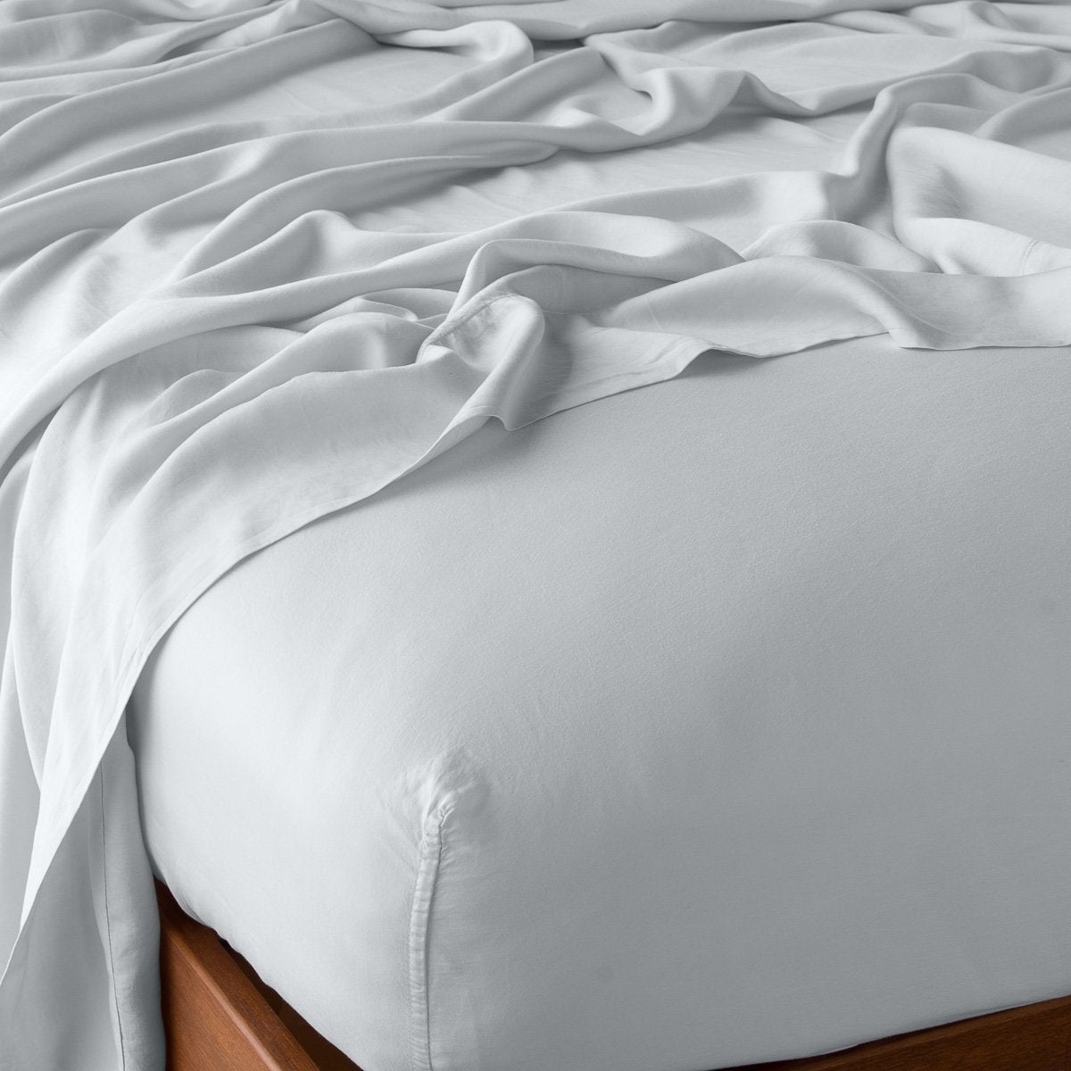 Cloud: fitted sheet with matching rumpled flat sheet - top corner view.