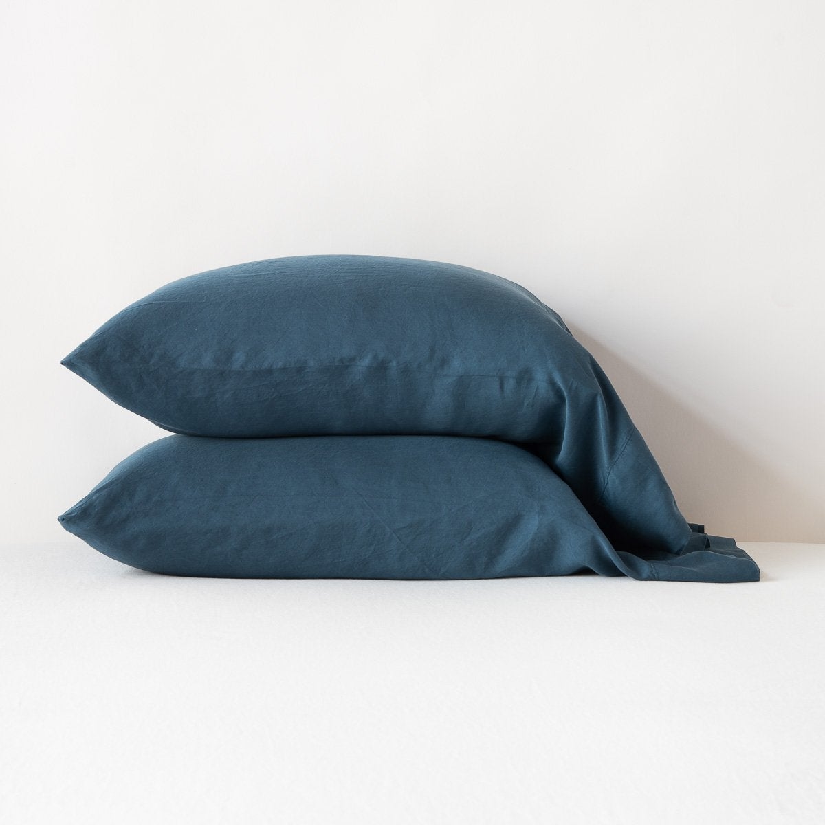 Midnight: sleeping pillows stacked neatly against a white backdrop - side view.