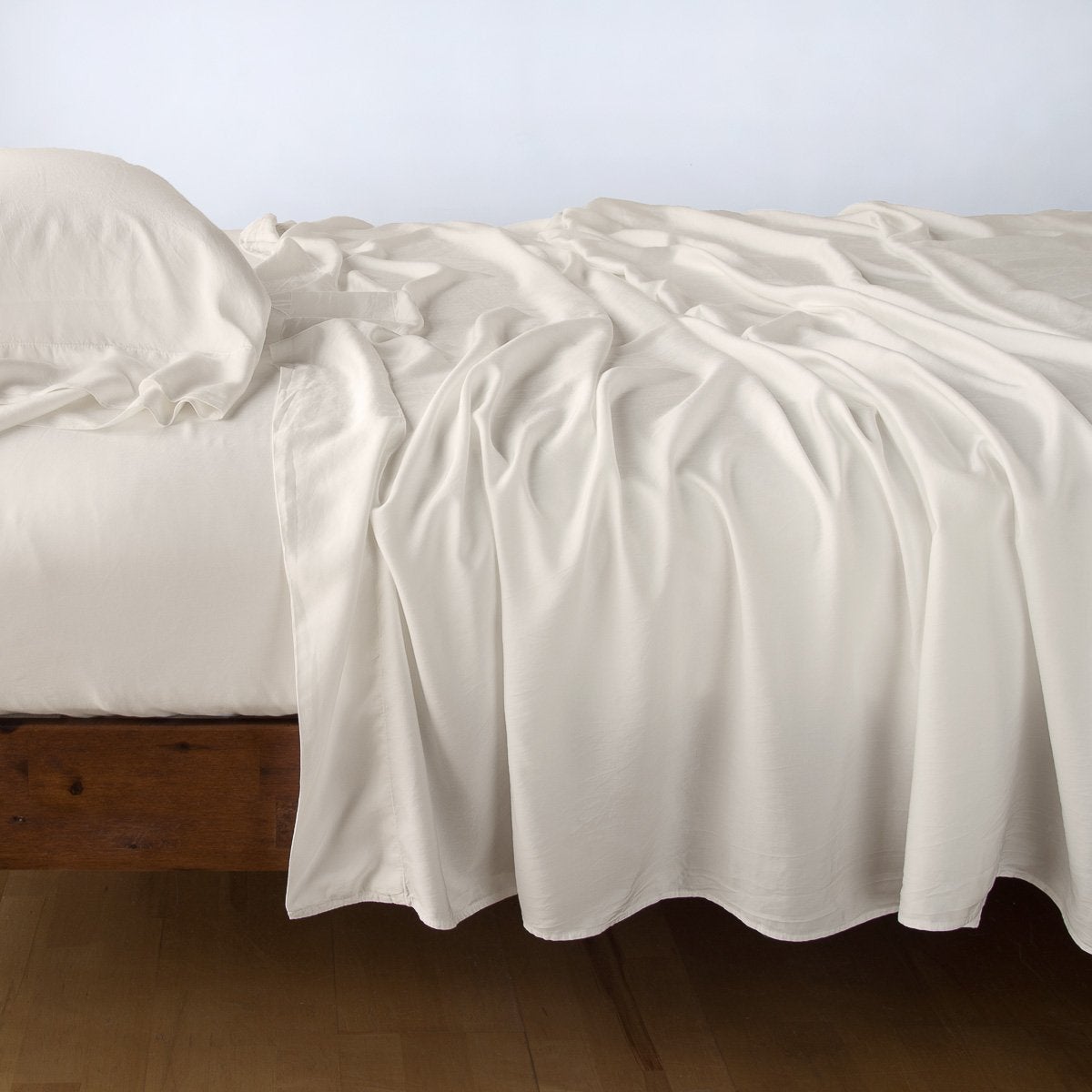 Parchment: sleeping pillow with matching rumpled sheeting - side view.