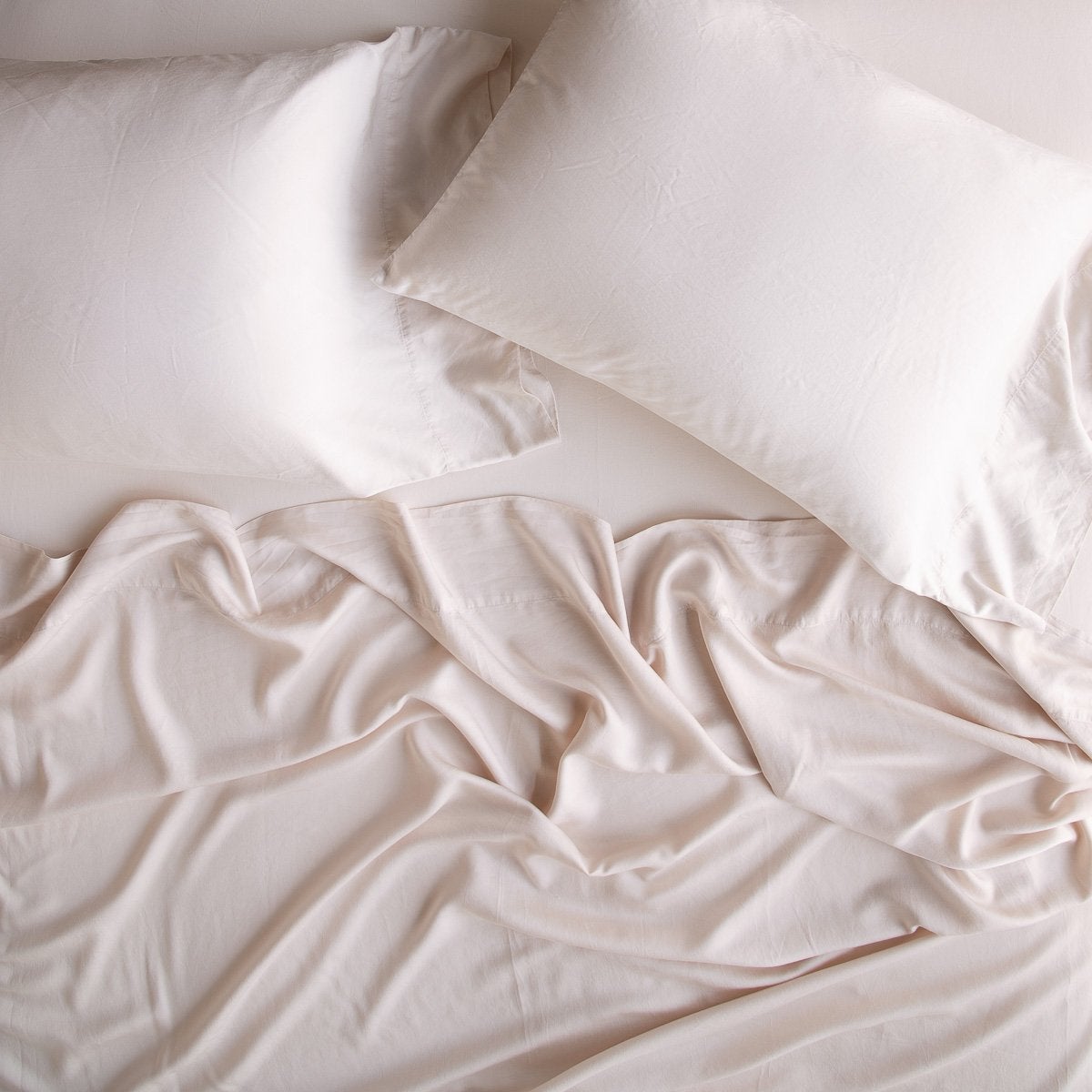 Pearl: sleeping pillows laid flat over rumpled matching sheeting - overhead view.
