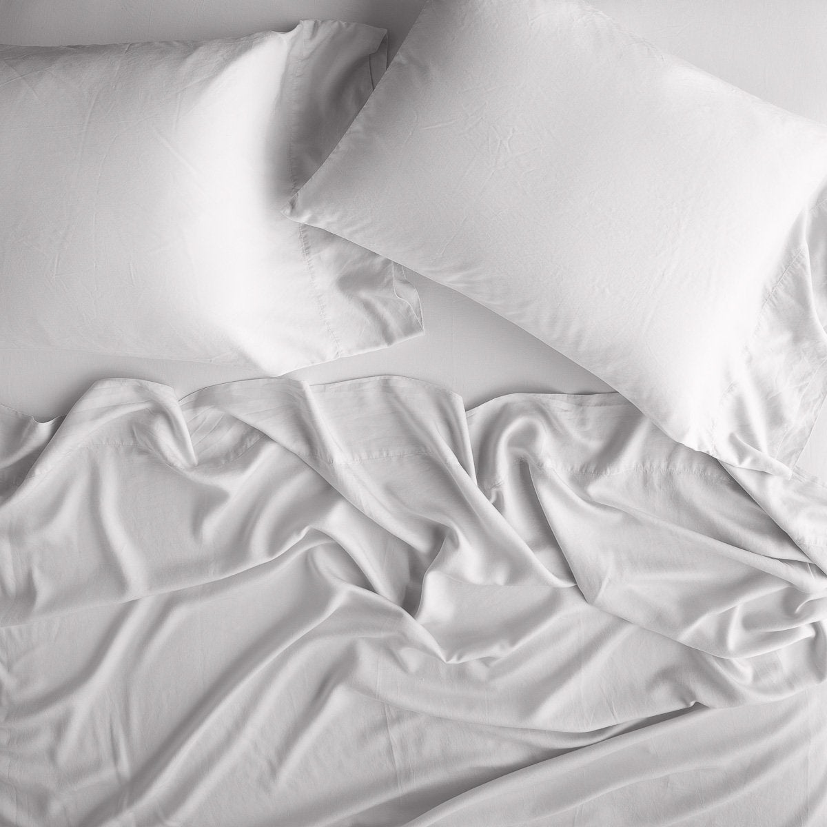 Sterling: sleeping pillows laid flat over rumpled matching sheeting - overhead view.