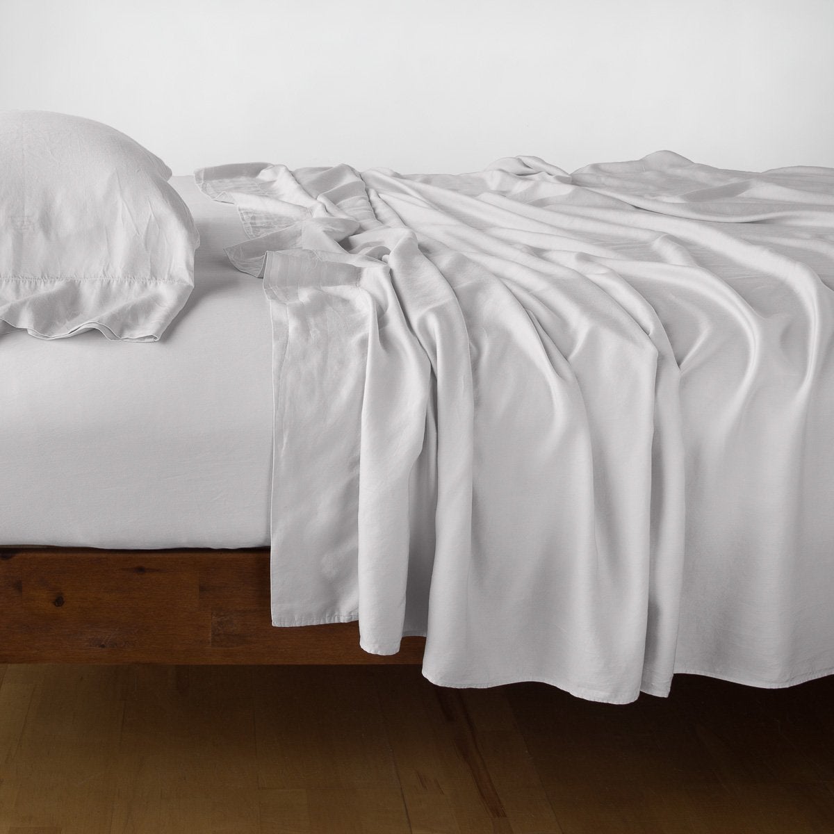 Sterling: sleeping pillow with matching rumpled sheeting - side view.