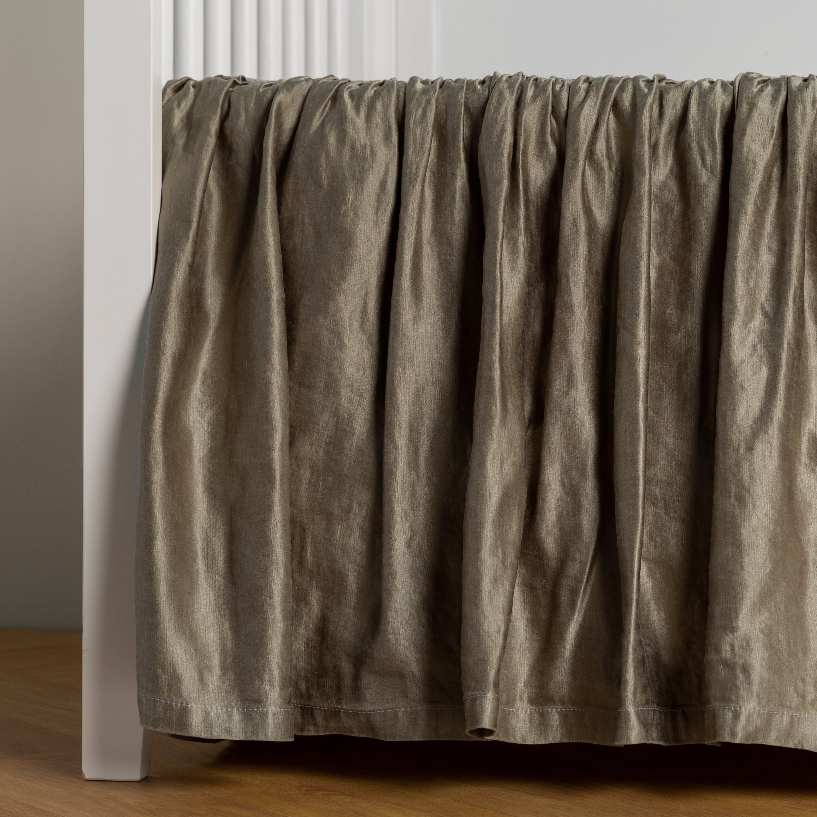 Fog:  charmeuse crib skirt shown on a white crib against a white wall and medium wood floor. 