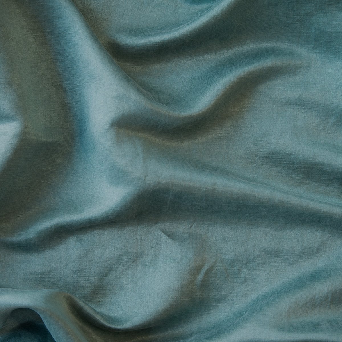 Cenote: Close-up of silk charmeuse in cenote, a vibrant, ocean-inspired blue-green.