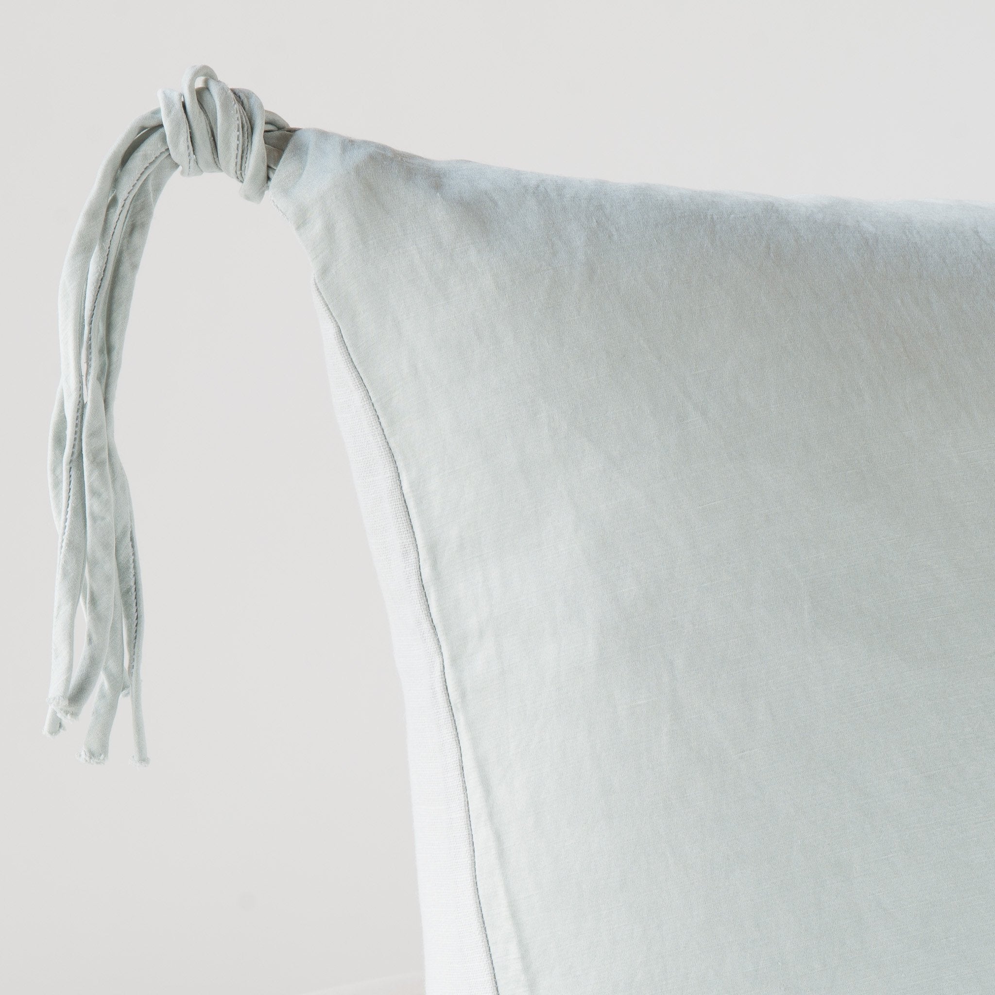 Cloud: Corner detail close-up, highlighting hand-tied charmeuse tassel.