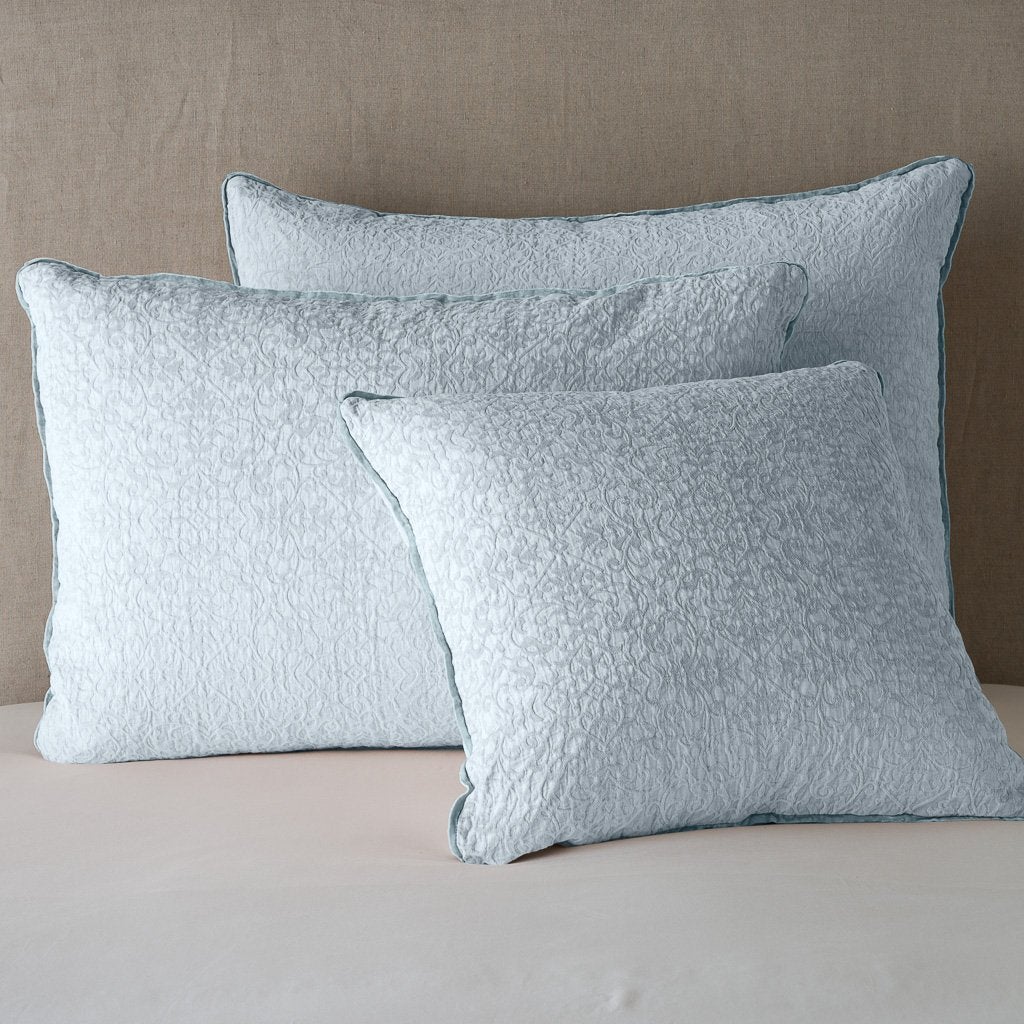 Cloud: Cotton chenille jacquard shams leaning upright against a neutral headboard.