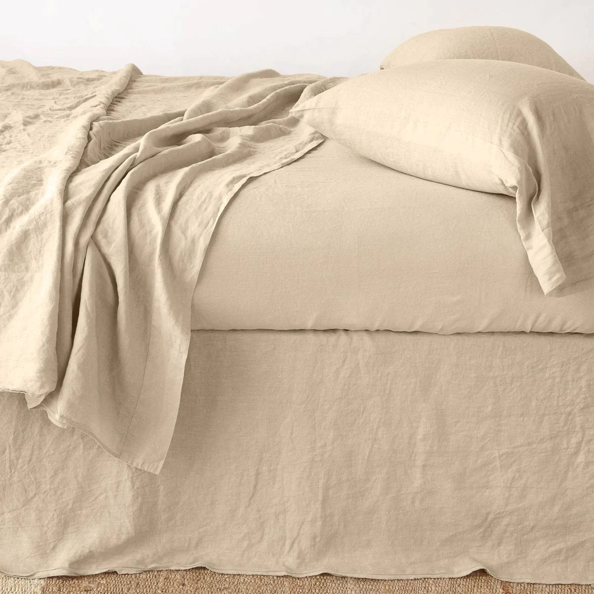 Honeycomb: Austin bed skirt in honeycomb  shown from the side on a bed with monochromatic sheeting, highlighting its tailored, ungathered style.