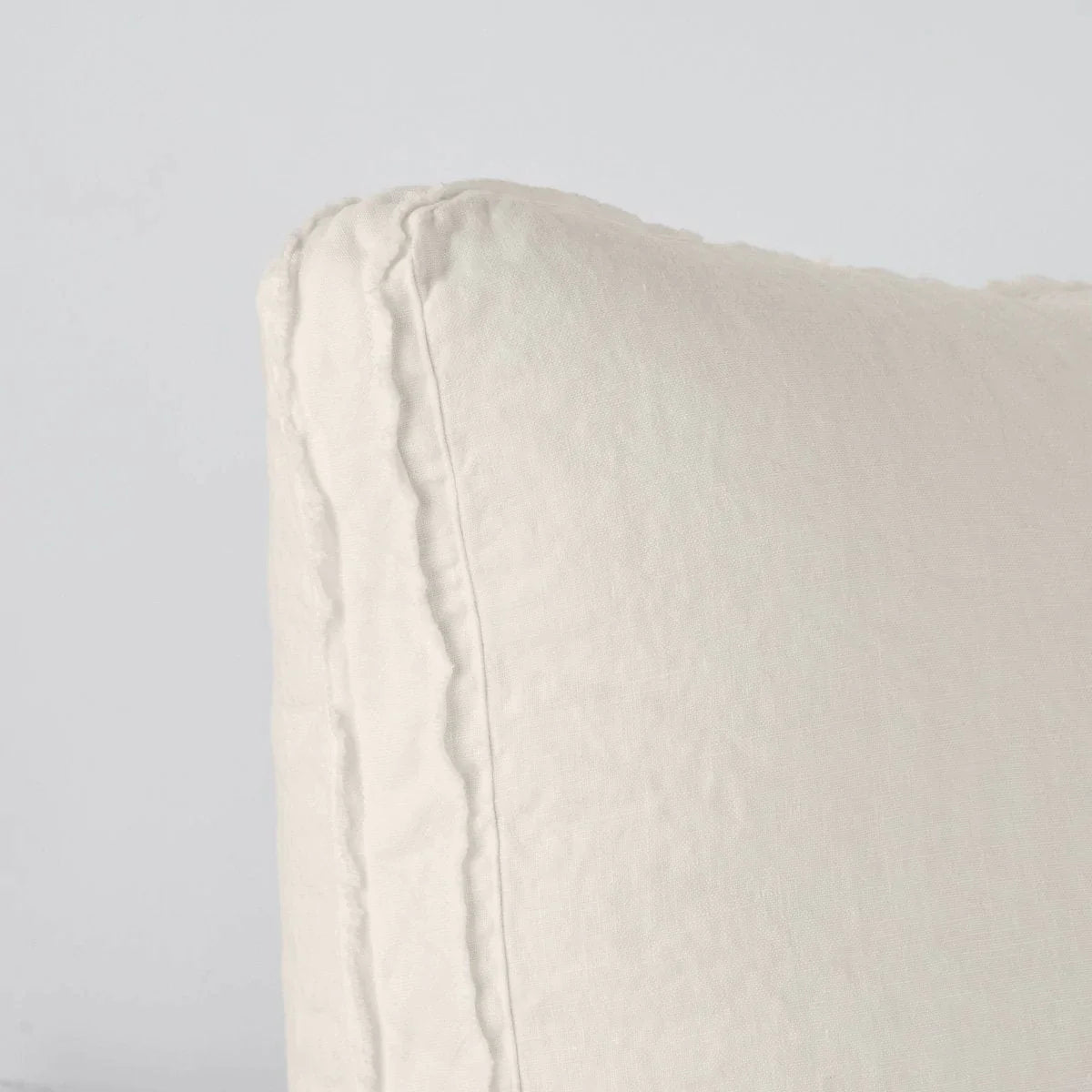 Parchment: Close-up angle of the corner of an Austin sham, highlighting the raw edge trim on either side of the gusset.