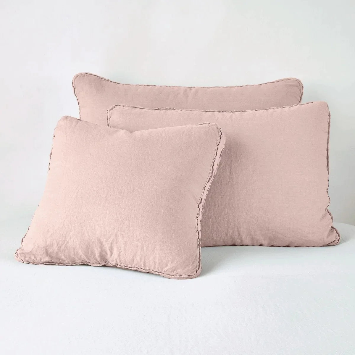 Rouge: Midweight linen shams in rouge colorway shown leaning upright on white background.