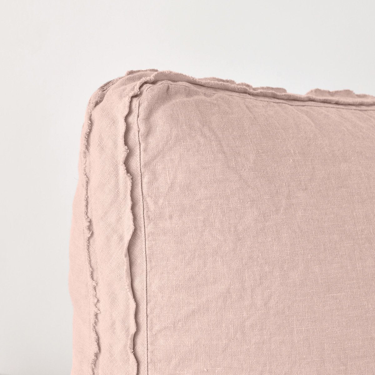 Rouge: Close-up angle of the corner of an Austin sham, highlighting the raw edge trim on either side of the gusset.