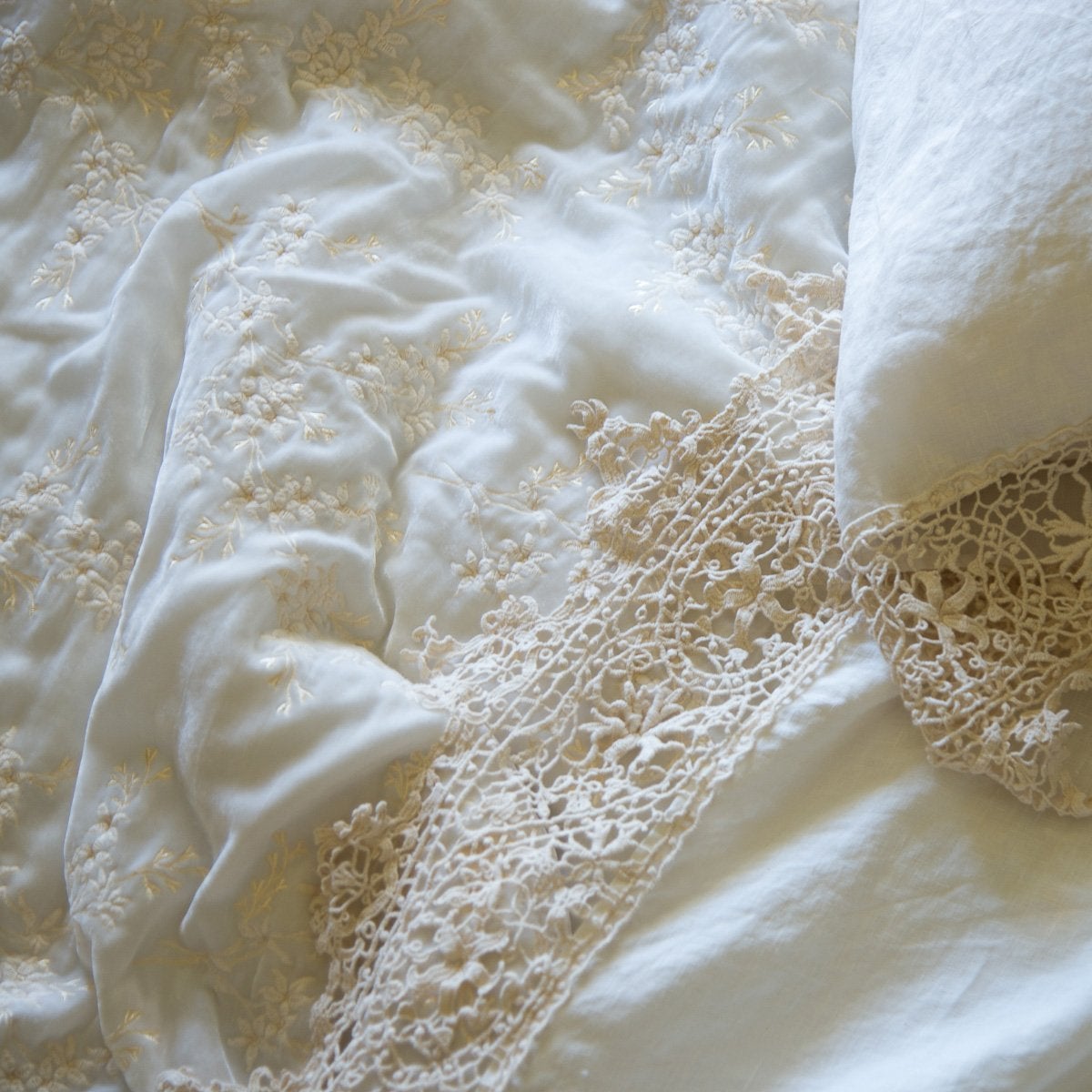 : Lynette's gold embroidery in winter white beautifully complements our linen with cotton lace in the same hue - close-up overhead angle.