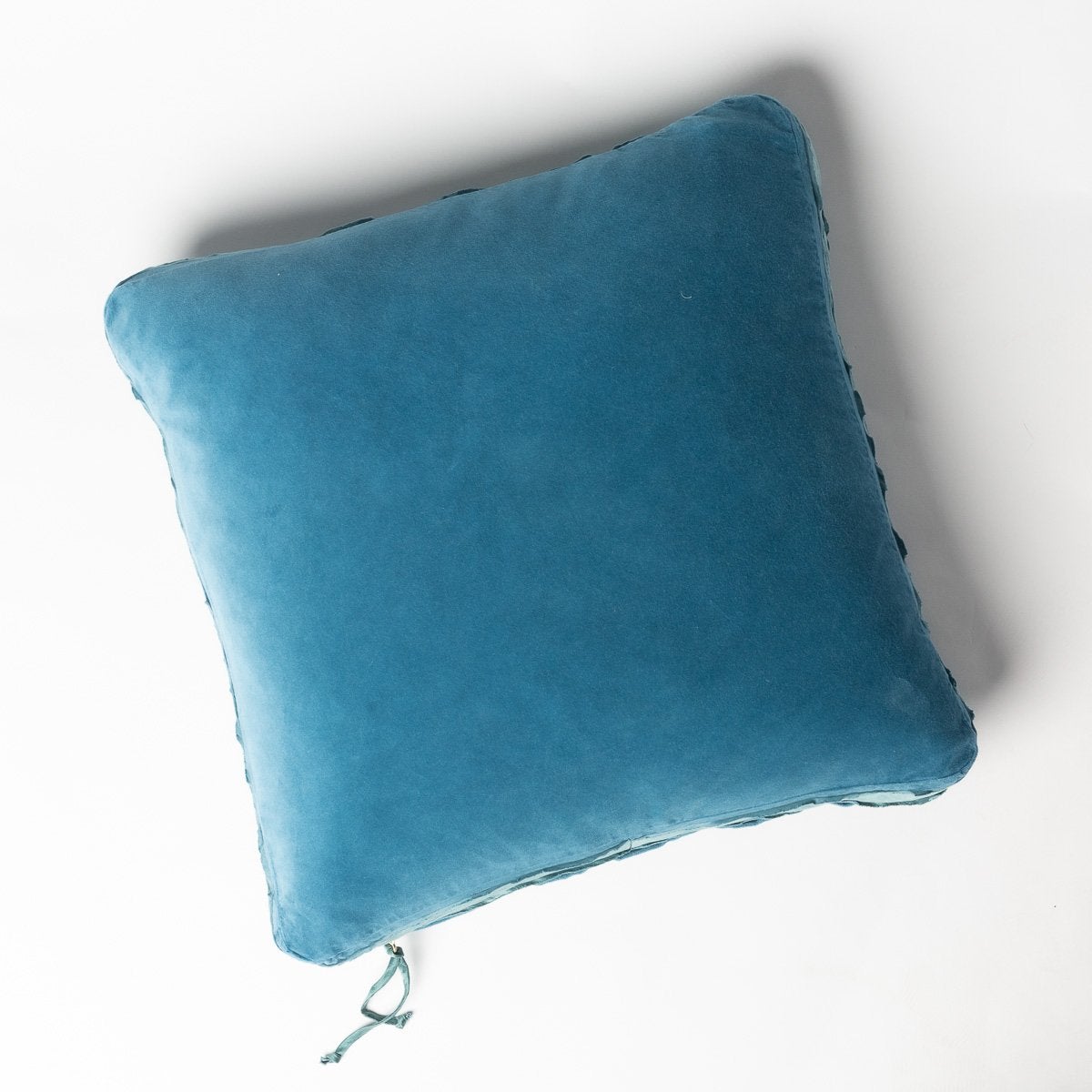 Cenote: Cotton velvet 24 by 24 pillow on a plain background - overhead view.