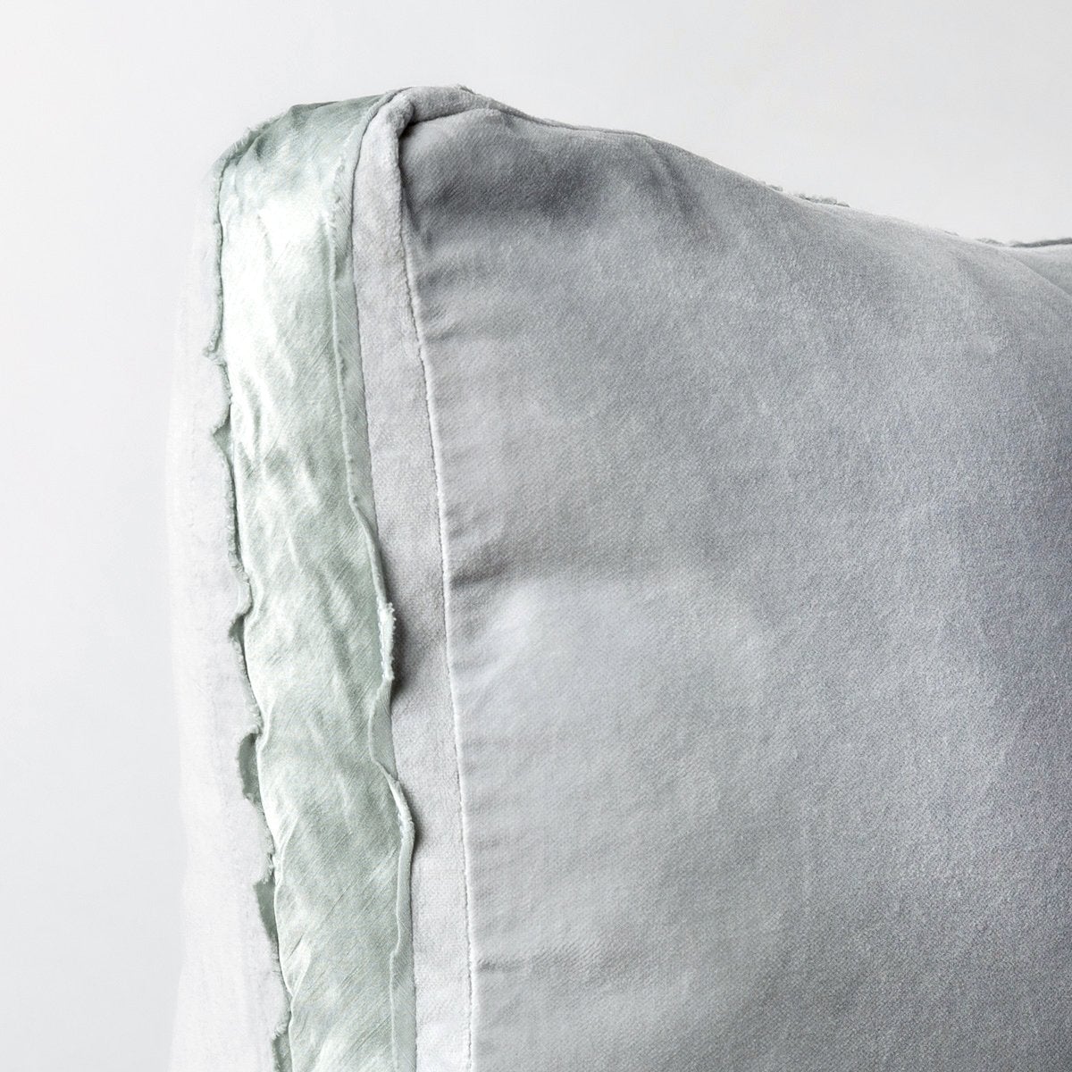 Cloud: : Corner detail close-up of cotton velvet 24 by 24 pillow, showcasing charmeuse gusset and raw edge trim.