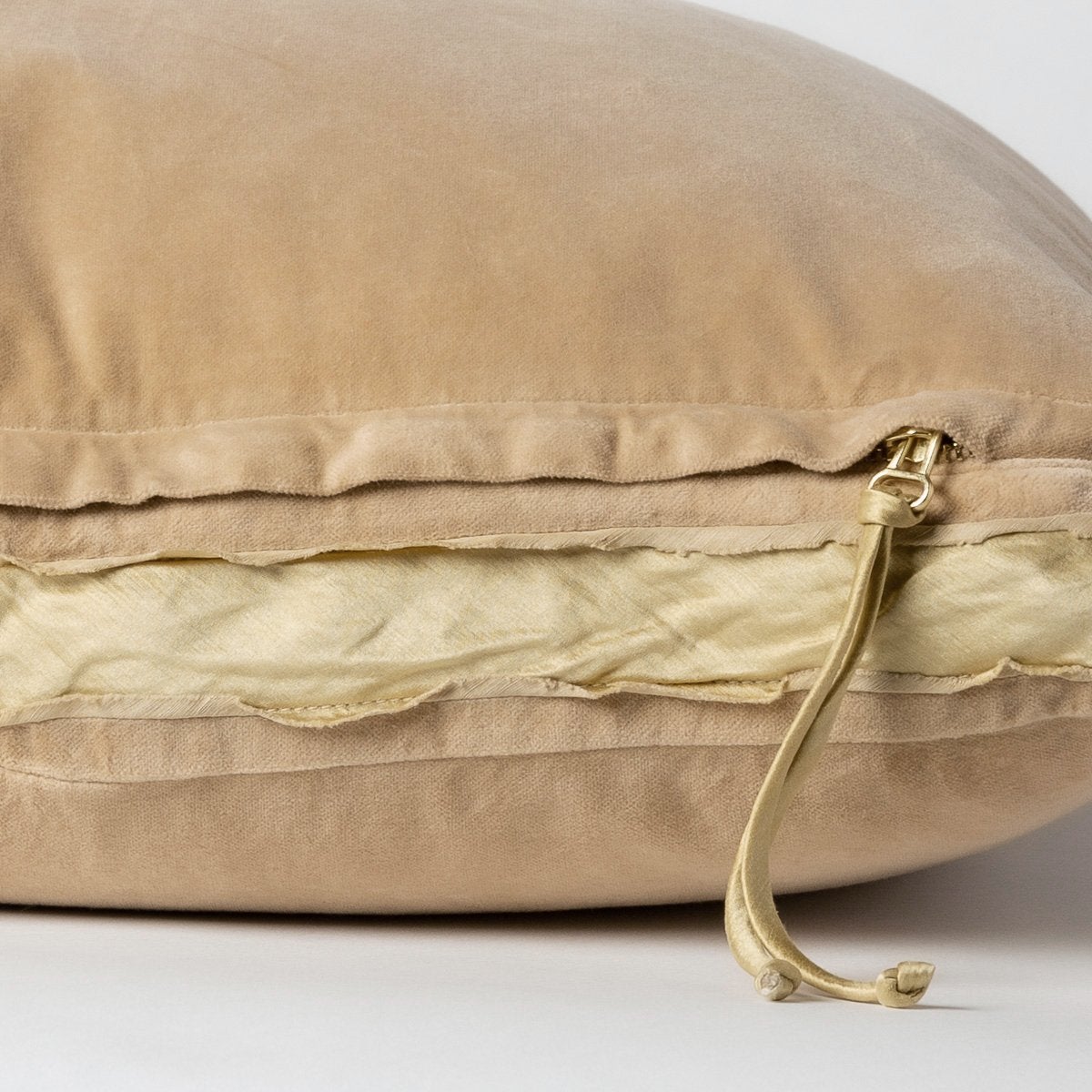 Honeycomb: Close-up of charmeuse gusset, raw-edge trim, and brass zipper detail on Harlow pillow - side view.