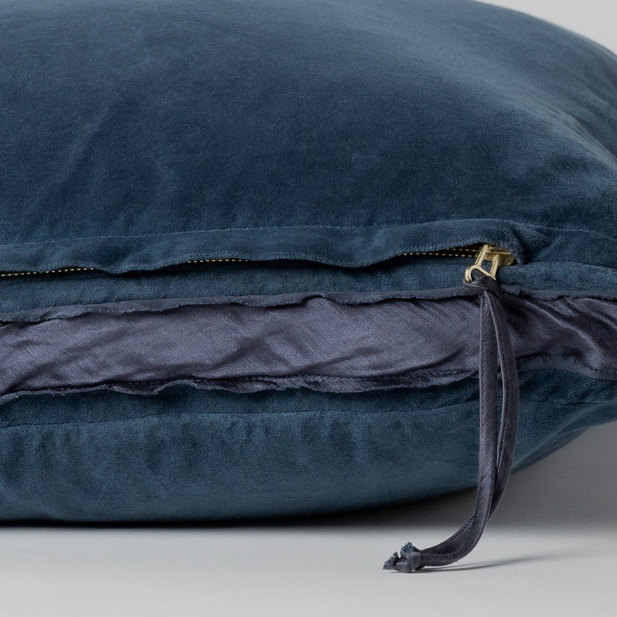 Midnight: Close-up of charmeuse gusset, raw-edge trim, and brass zipper detail on Harlow pillow - side view.