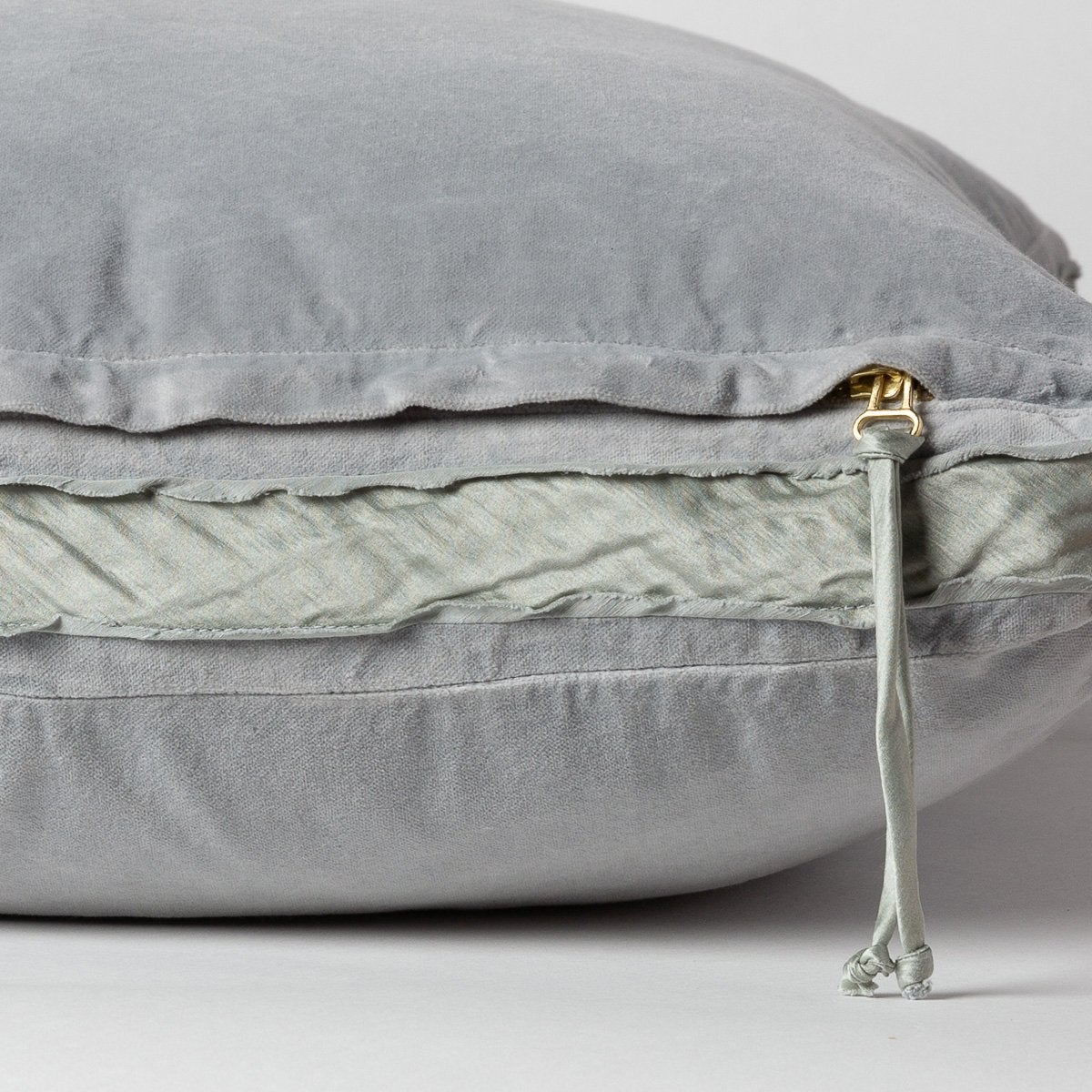 Mineral: Close-up of charmeuse gusset, raw-edge trim, and brass zipper detail on Harlow pillow - side view.