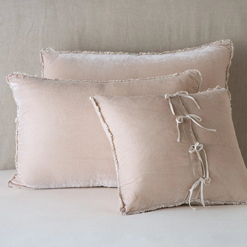 Pearl: Silk velvet  shams with a petite ruffle leaning upright against a neutral headboard. The front sham is backwards, showcasing the charmeuse tie closures.