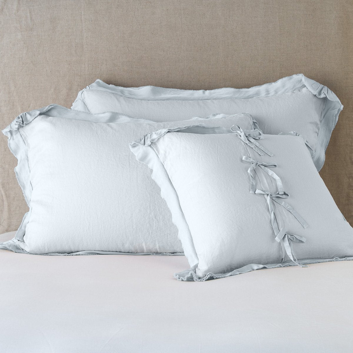 Cloud: satin trimmed linen shams showing the front and back of the sham with tie closures. 