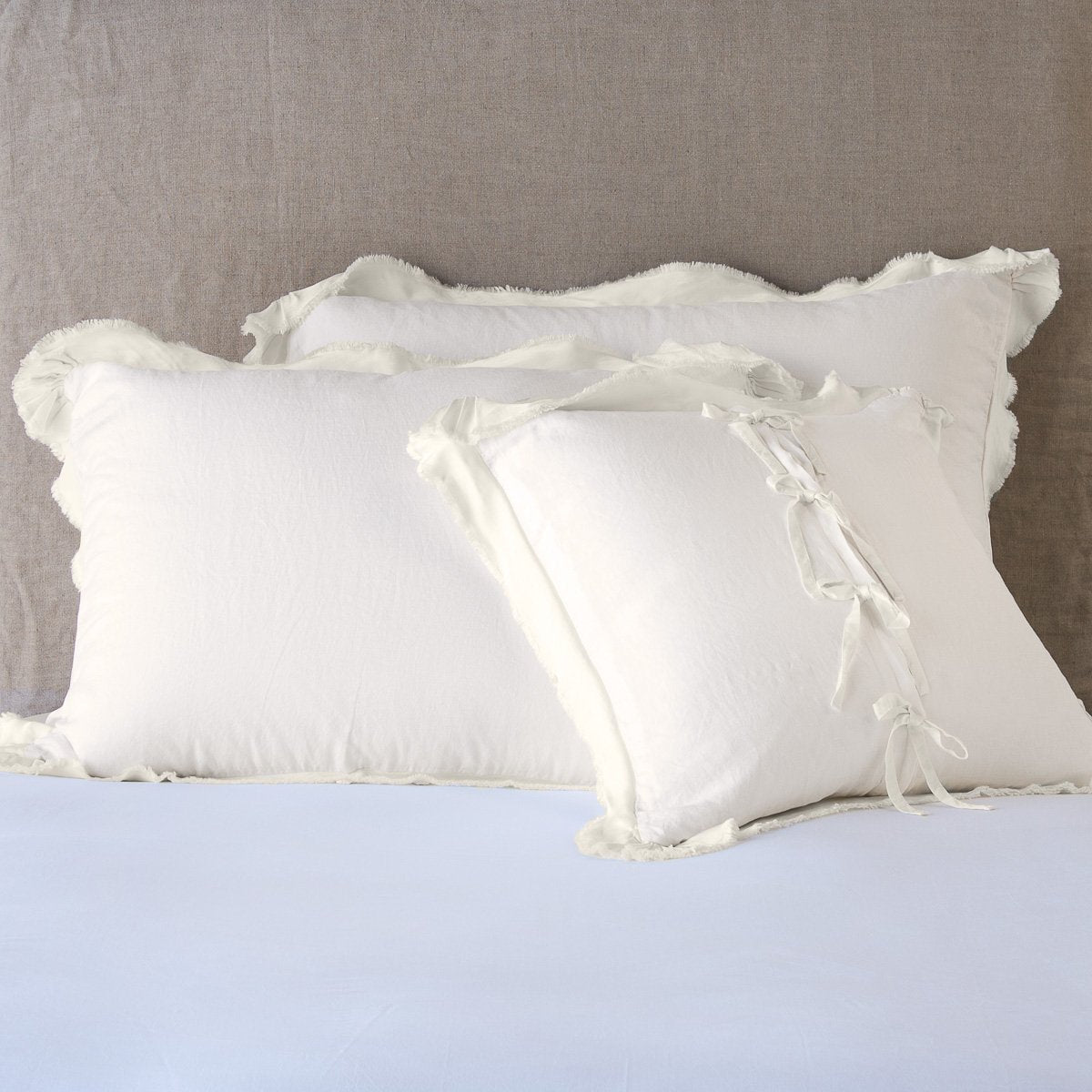 Parchment: satin trimmed linen shams showing the front and back of the sham with tie closures. 