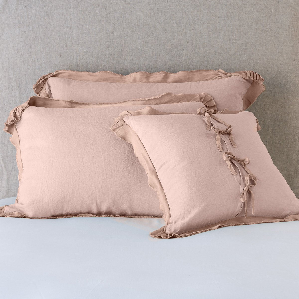 Rouge: satin trimmed linen shams showing the front and back of the sham with tie closures. 