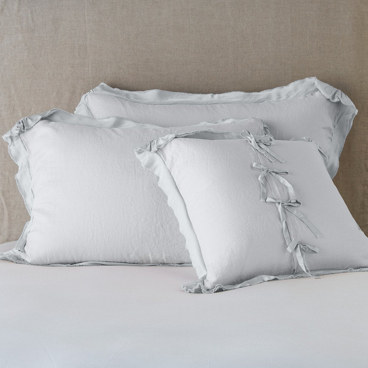 Sterling: satin trimmed linen shams showing the front and back of the sham with tie closures. 