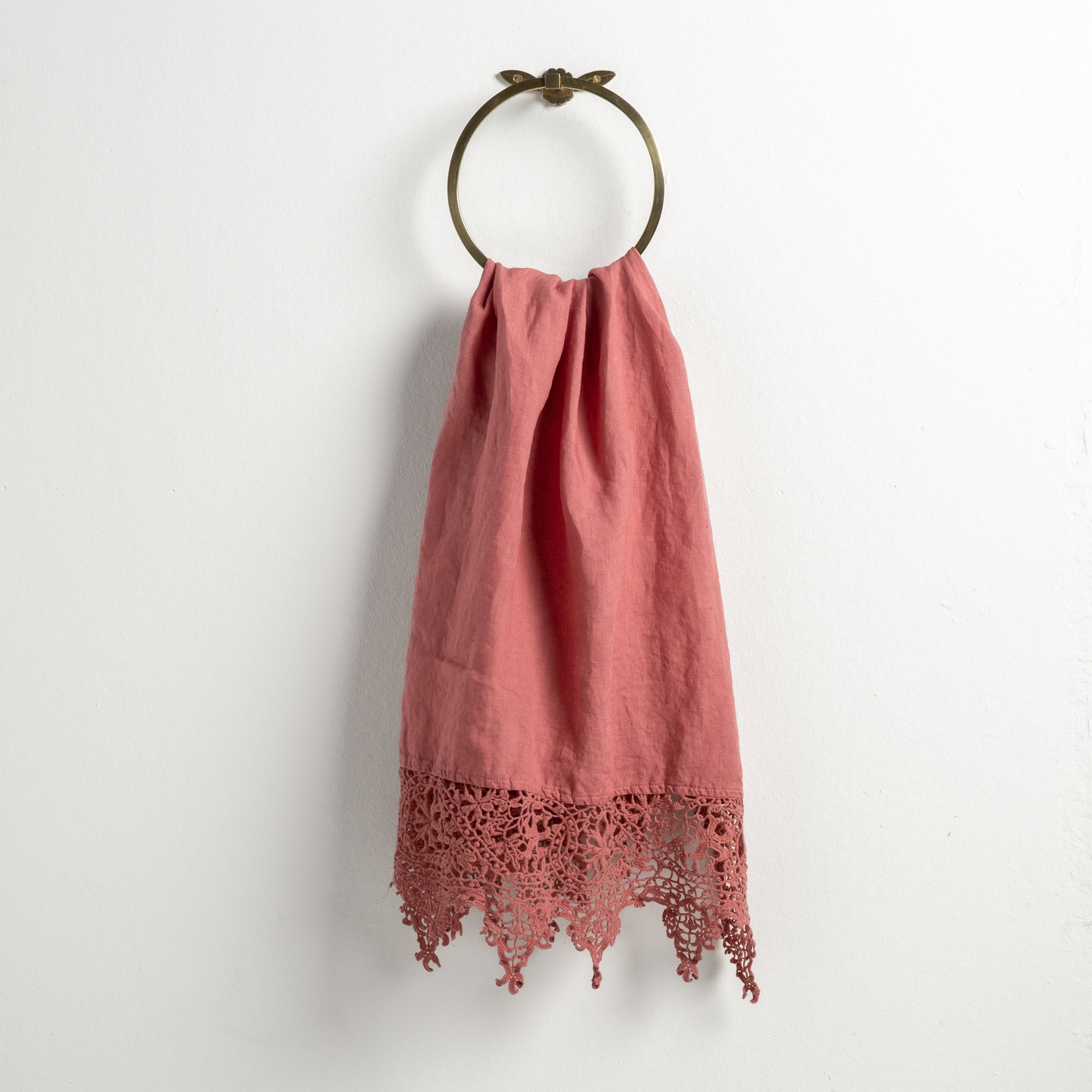 Poppy: Lace trimmed linen guest towel  draped through a decorative towel ring against a plain white background.