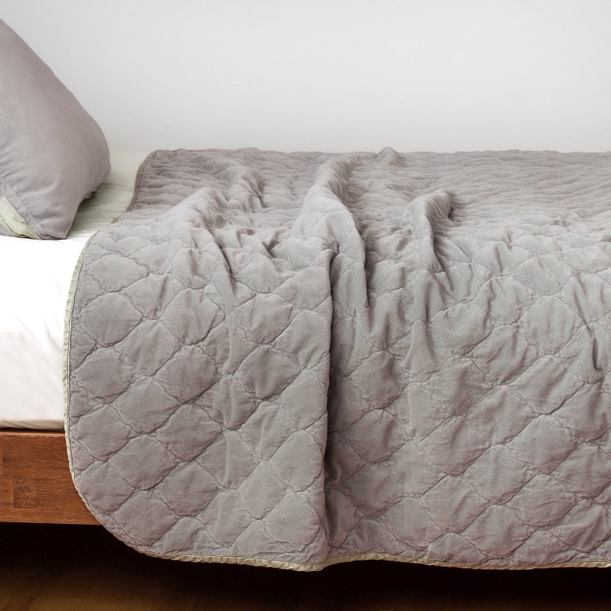 Fog: Quilted cotton velvet coverlet draped over a white fitted sheet - side view.