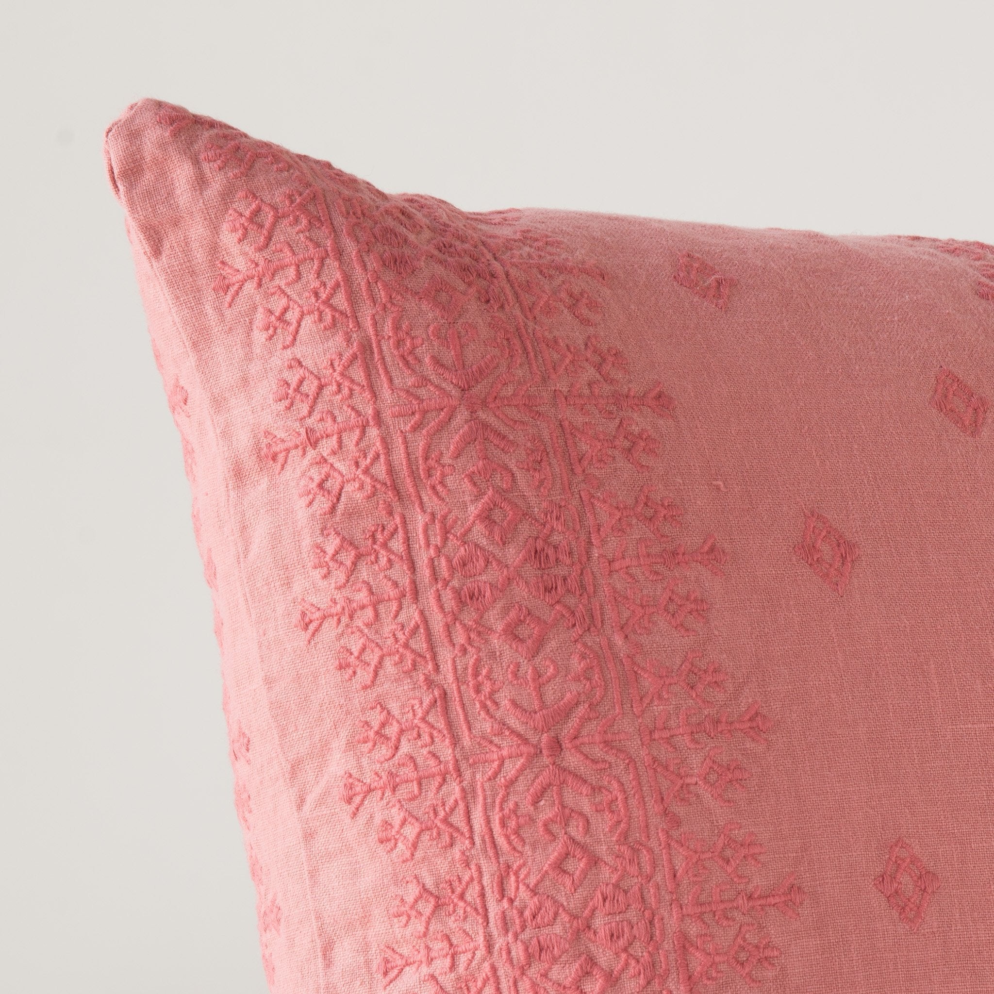 Poppy: Close-up of pillow corner, showcasing the embroidery pattern detail.