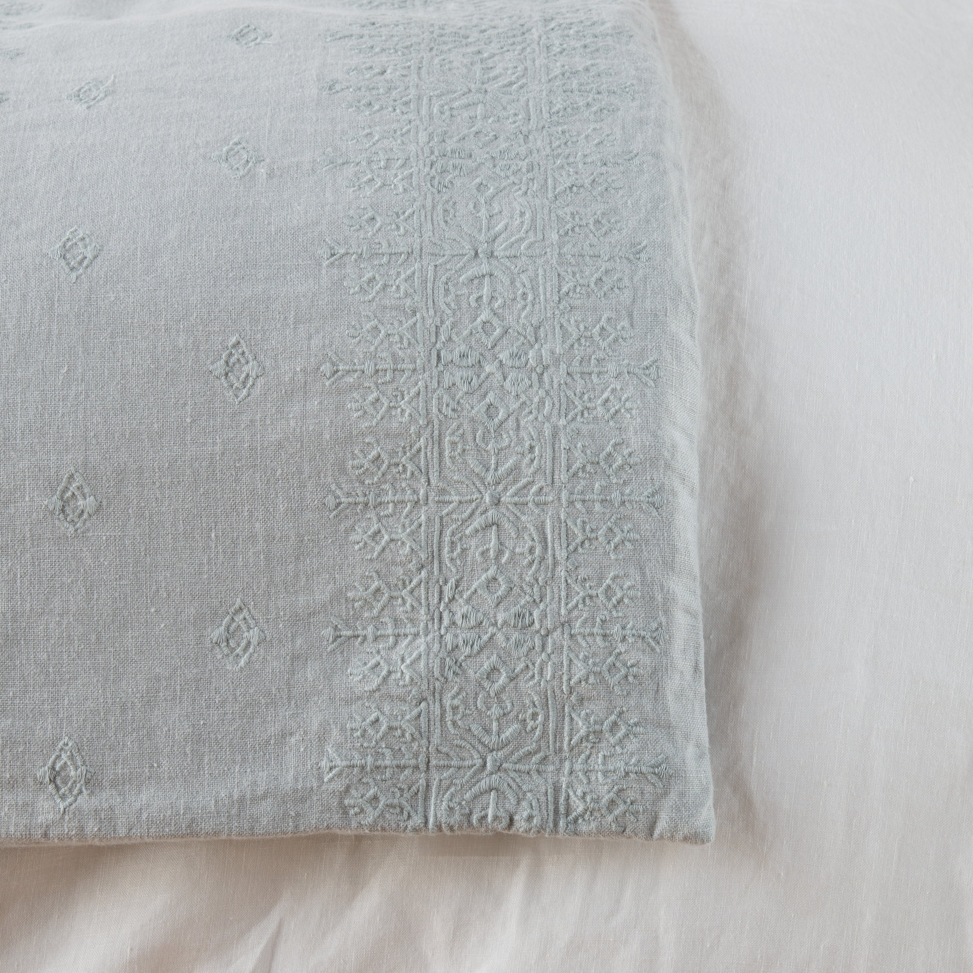Mineral: Close-up of corner against a white background, showcasing embroidery pattern detail - overhead view.