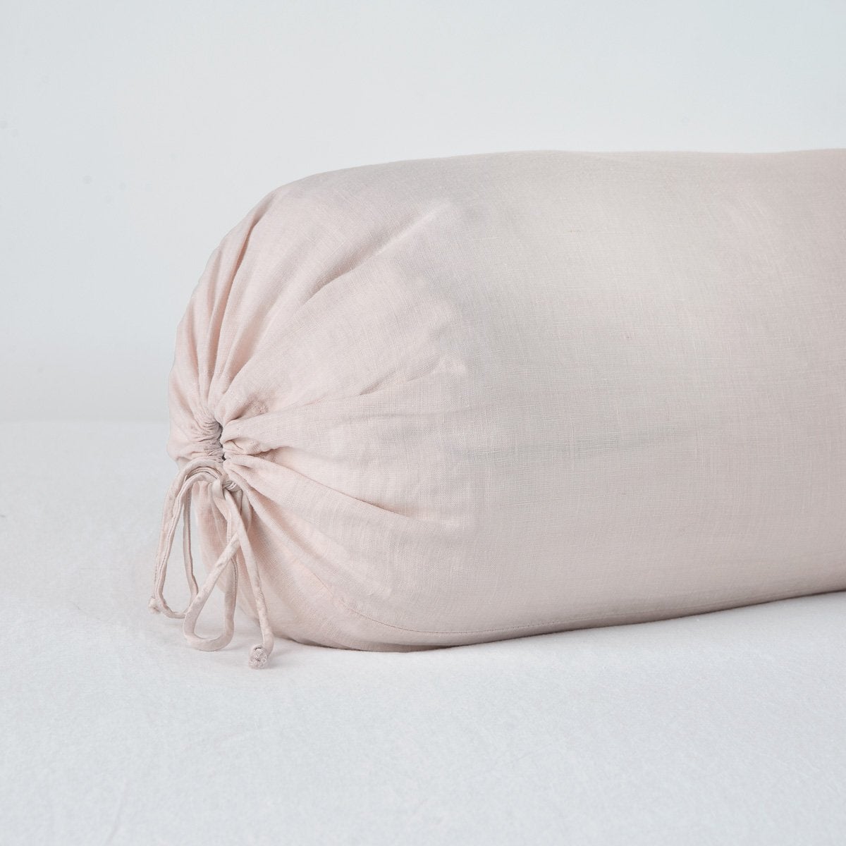 Pearl: Close-up bolster end detail, angled view to show gathered closure and satin ties.