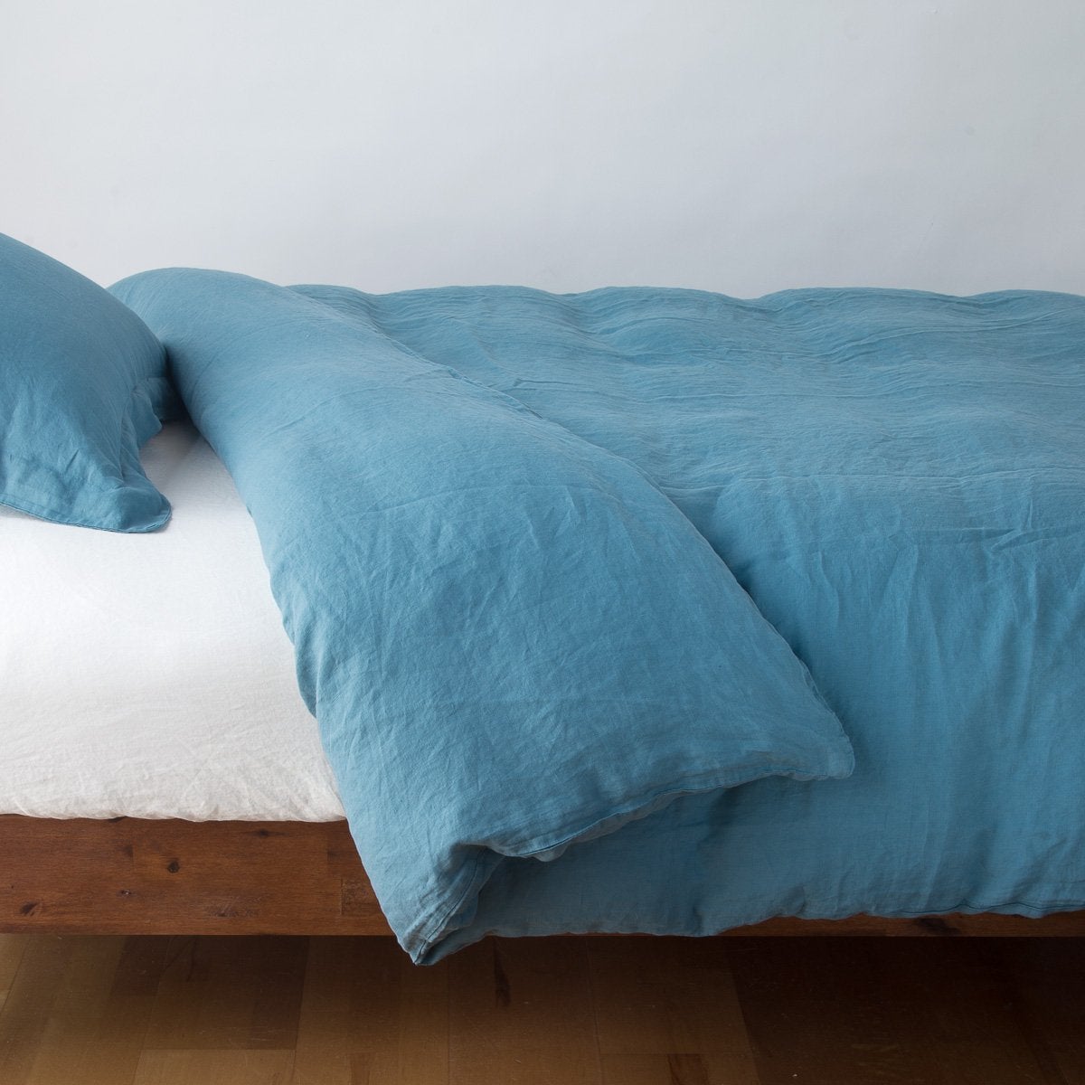 Cenote: duvet cover neatly folded back over white linen sheeting - side view.