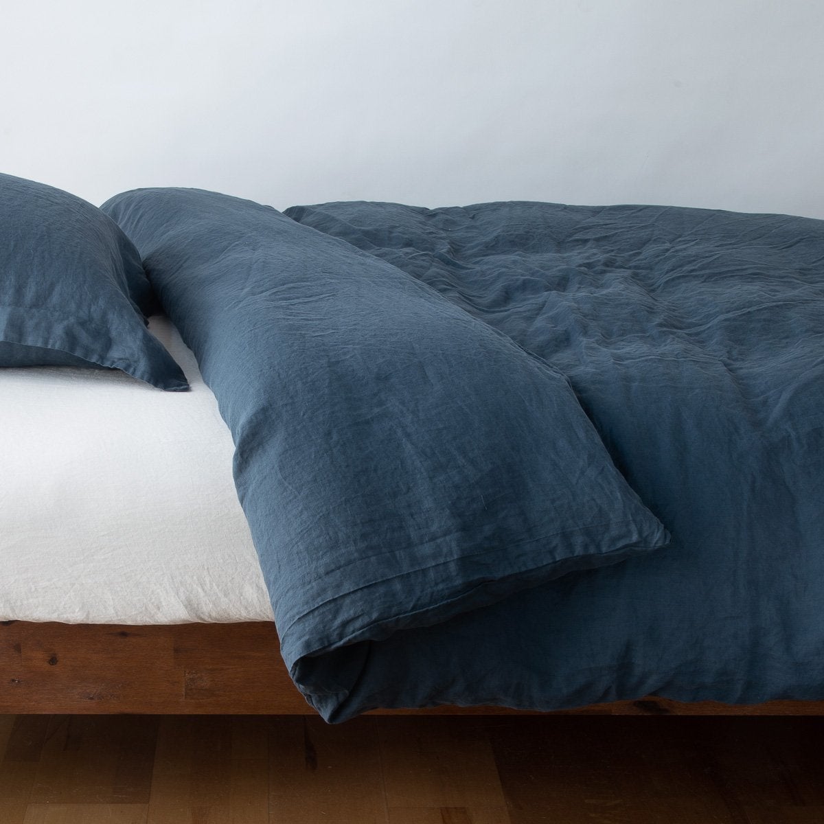 Midnight: duvet cover neatly folded back over white linen sheeting - side view.