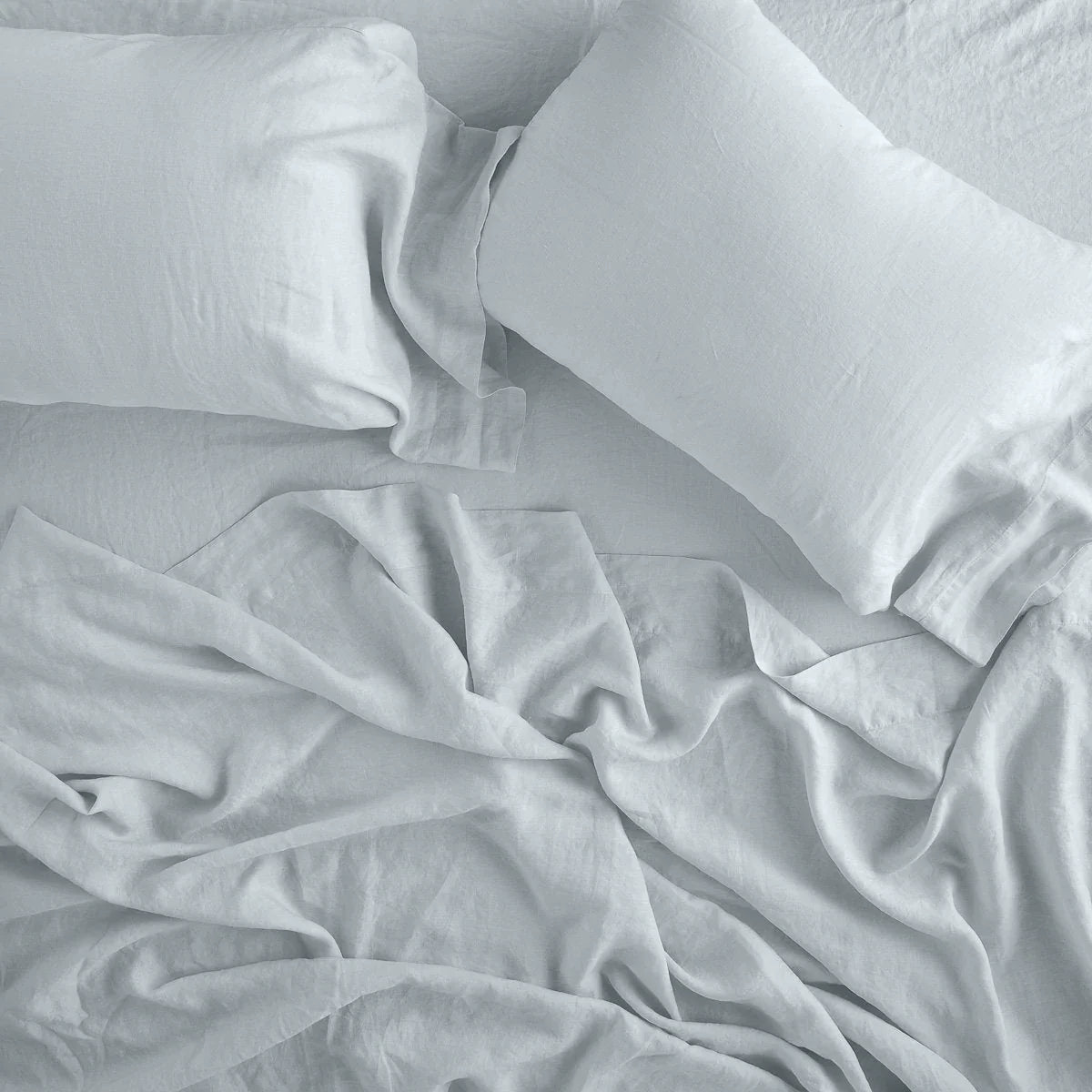 Cloud: fitted sheet with matching rumpled flat sheet and sleeping pillows - overhead view.