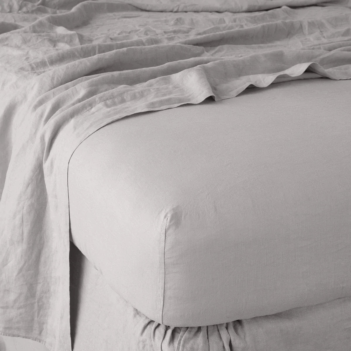Fog: close up of fitted sheet with matching rumpled flat sheet - corner view.