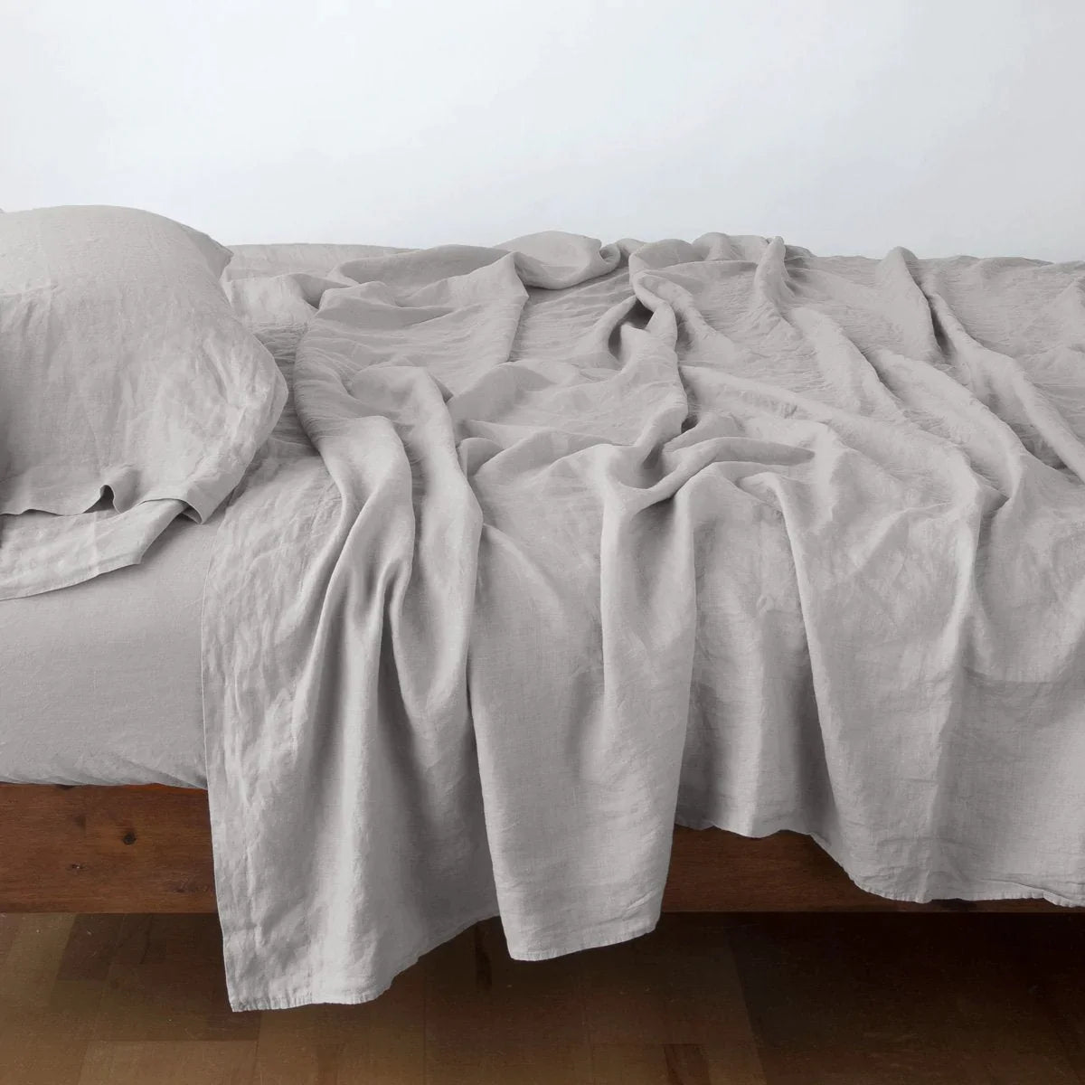 Fog: fitted sheet with matching rumpled flat sheet and sleeping pillow - side view.