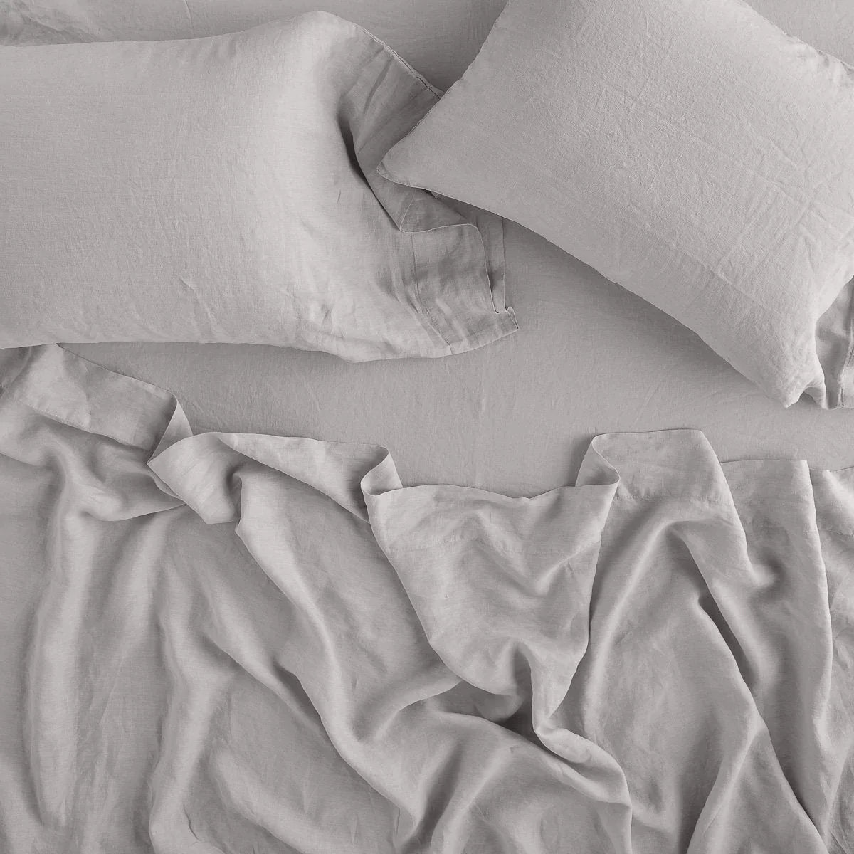 Fog: fitted sheet with matching rumpled flat sheet and sleeping pillows - overhead view.