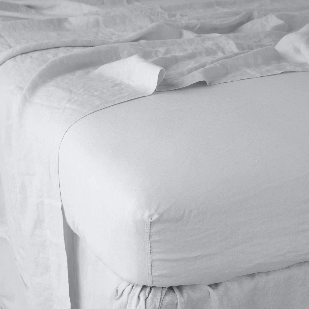 Sterling: close up of fitted sheet with matching rumpled flat sheet - corner view.