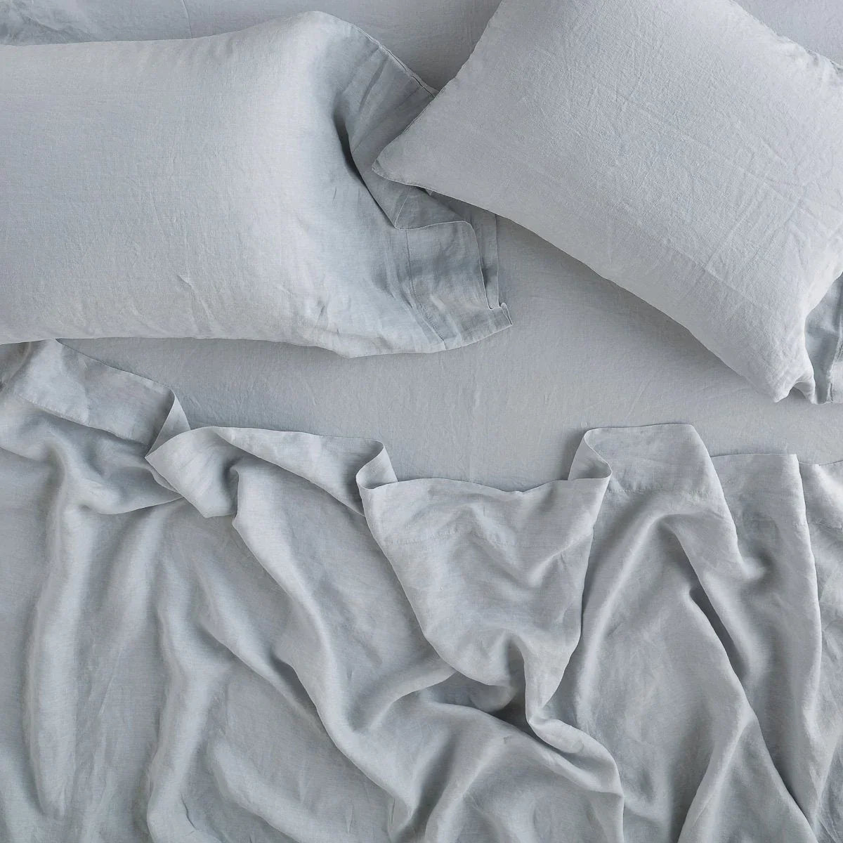 Mineral: Rumpled sheeting with matching sleeping pillows - overhead view.
