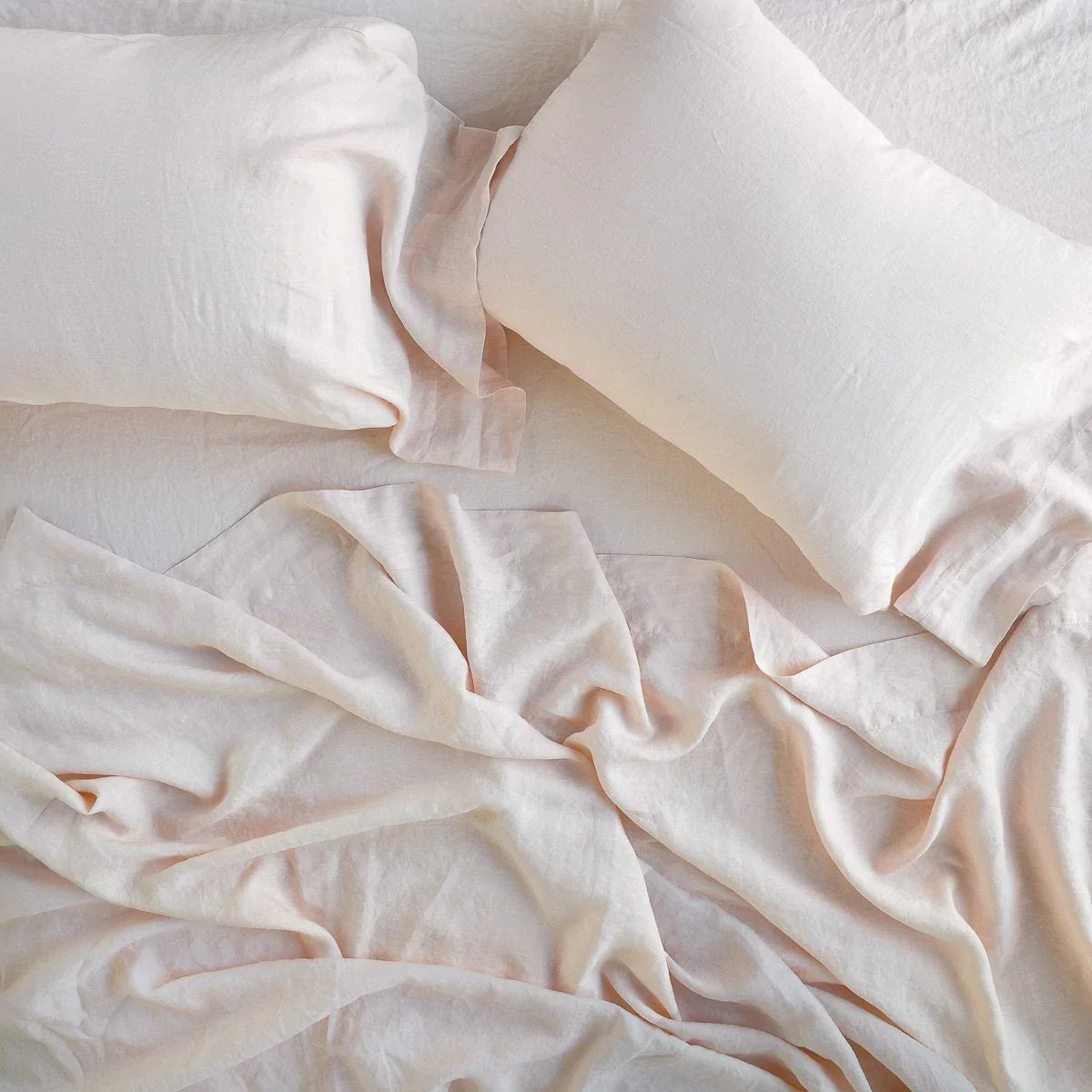 Pearl: Rumpled sheeting with matching sleeping pillows - overhead view.