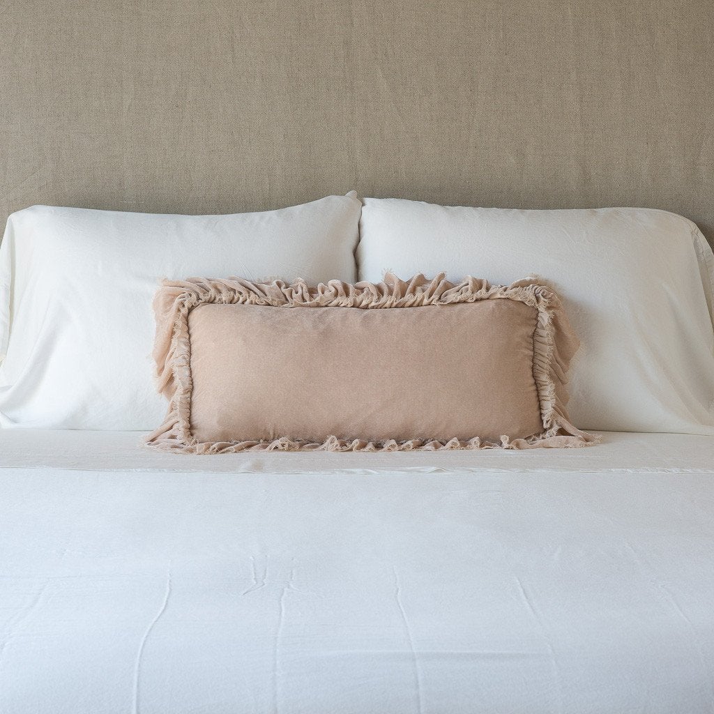 Pearl: pillow on a white bed - cropped end of bed view.