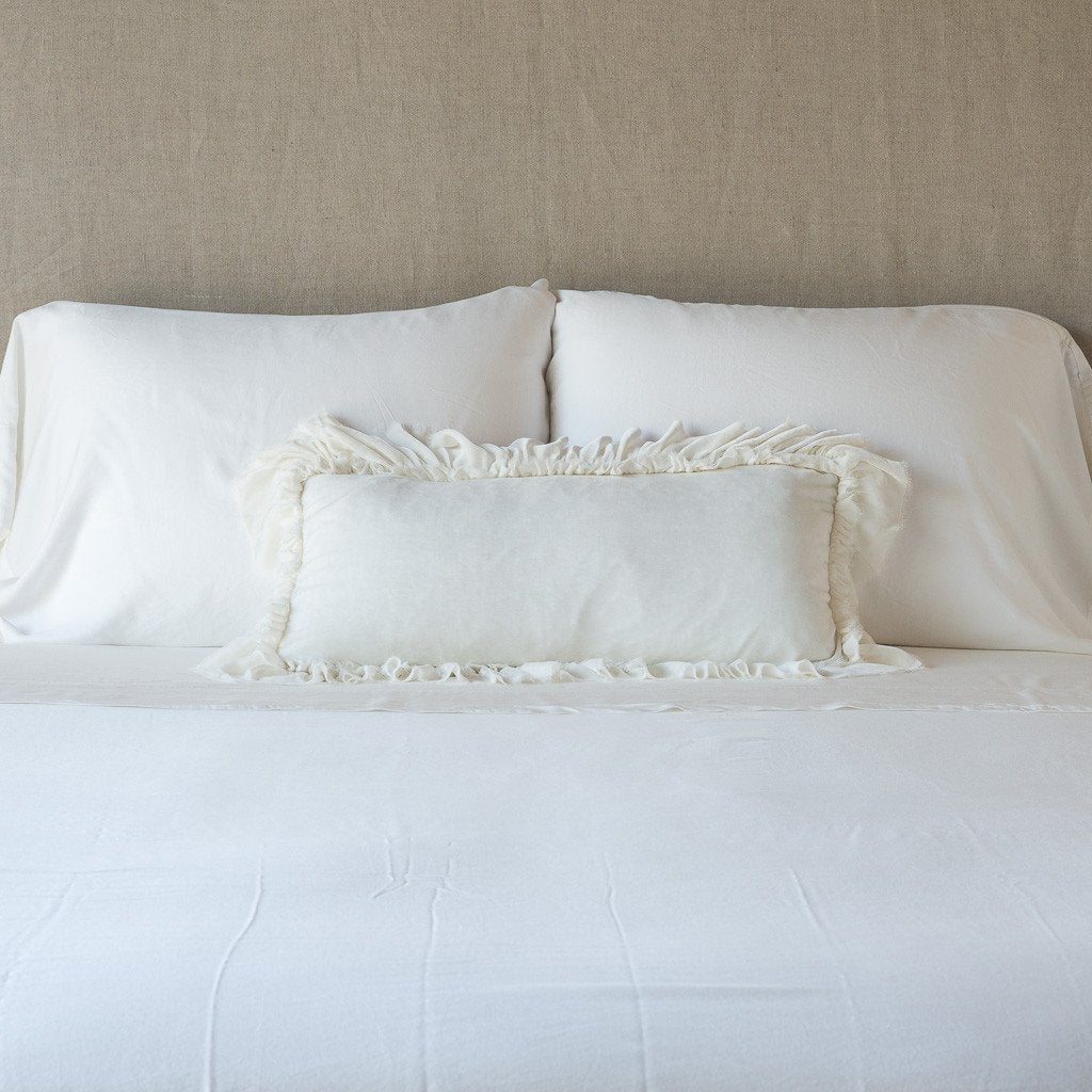 Winter White: pillow on a white bed - cropped end of bed view.