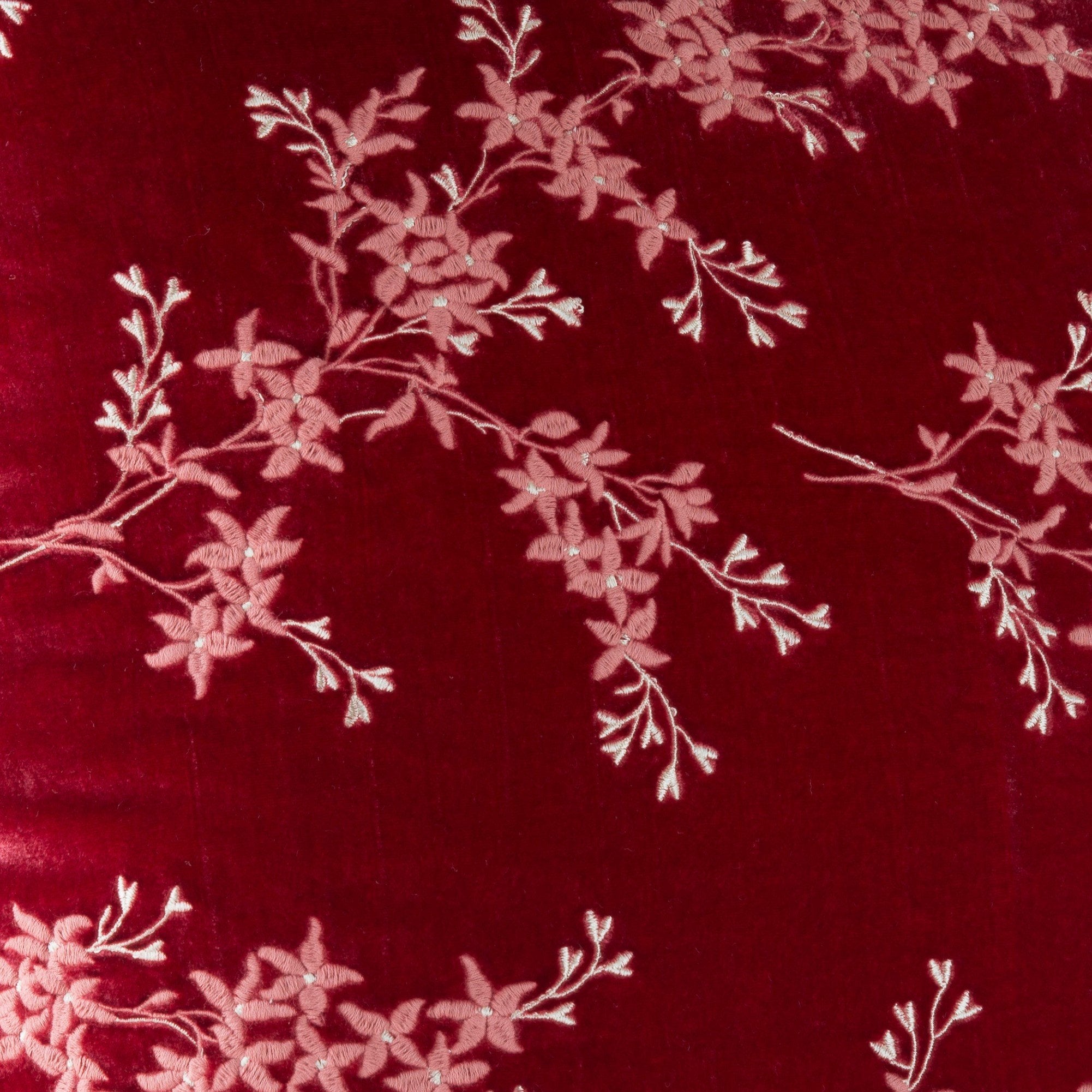 Poppy: A close up of Lynette embroidered silk velvet, in poppy, a vibrant reddish pink.