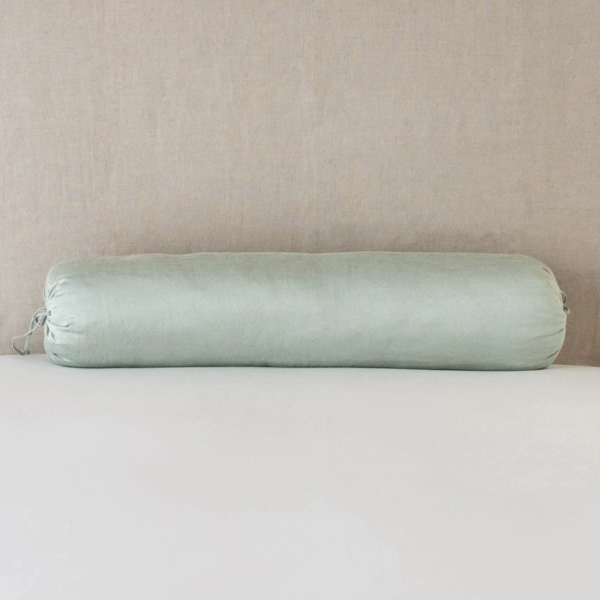 Eucalyptus: bolster on white sheets with a neutral headboard.
