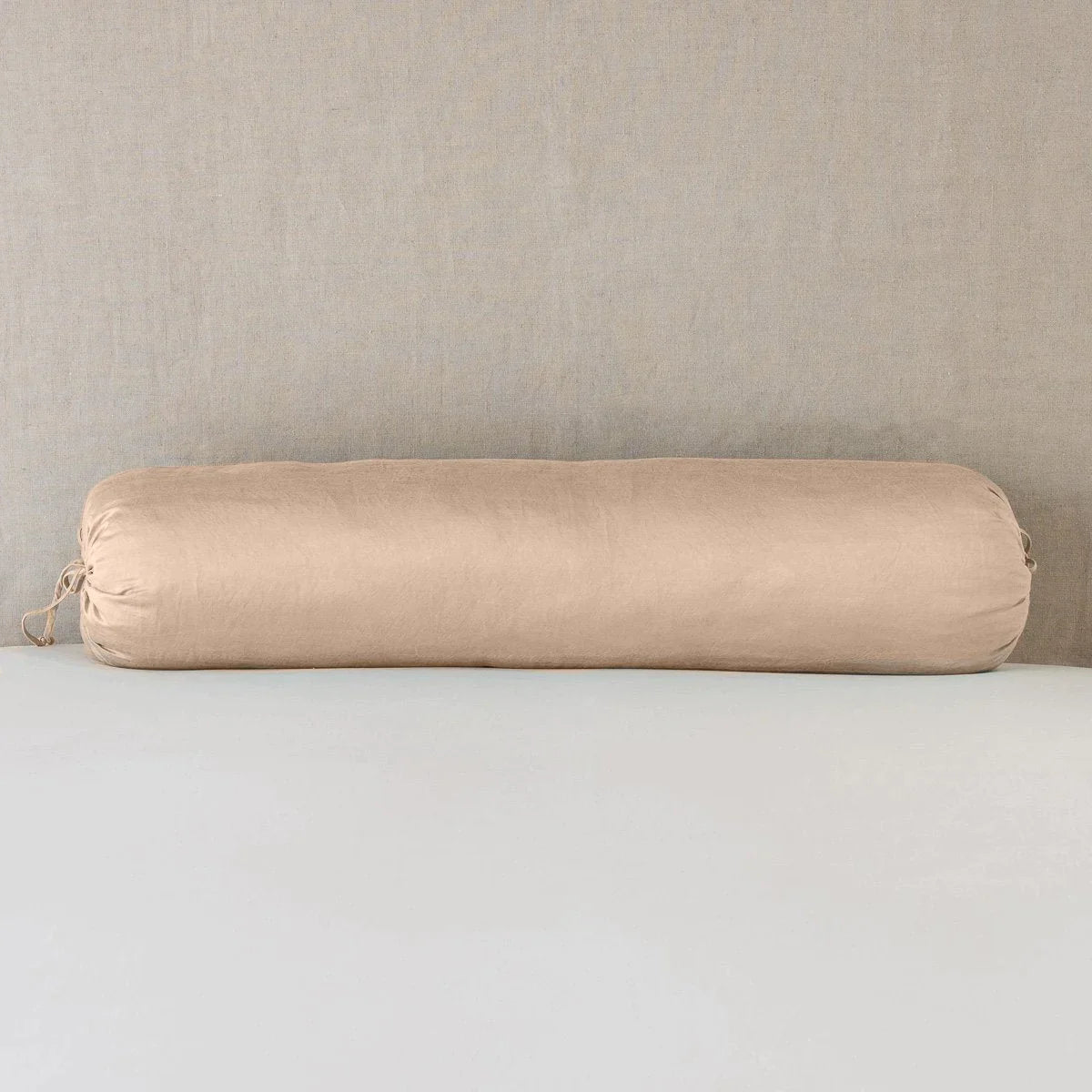 Rouge: bolster on white sheets with a neutral headboard.