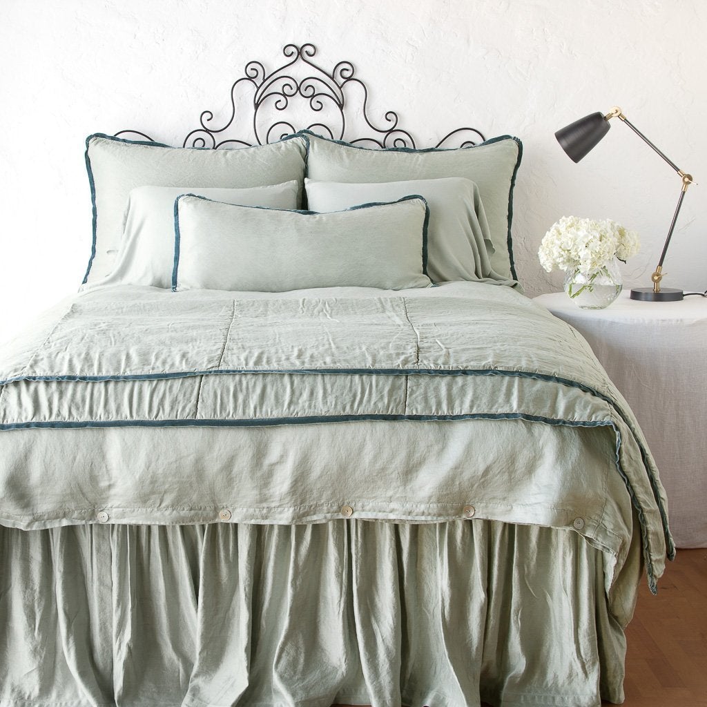Eucalyptus: throw blanket folded at the end of a monochromatic, charmeuse bed - end of bed view.