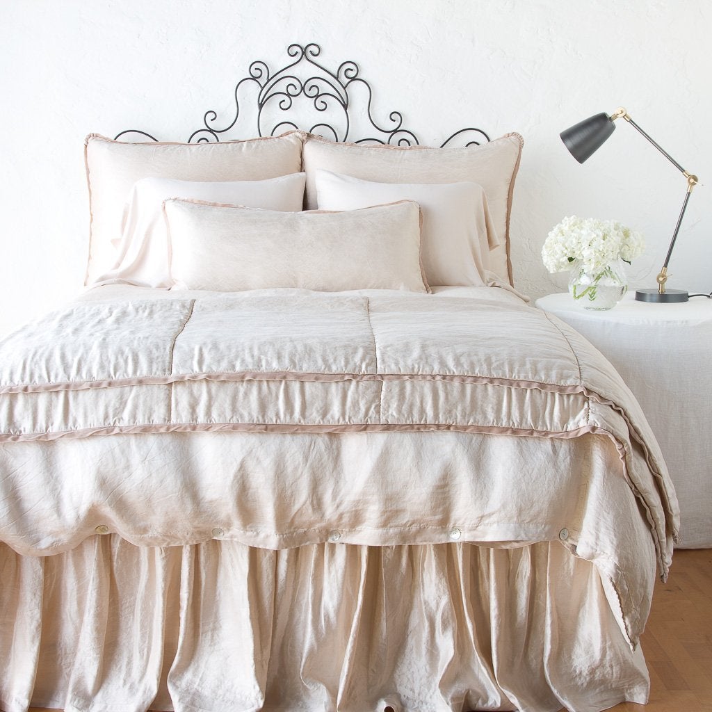 Pearl: throw blanket folded at the end of a monochromatic, charmeuse bed - end of bed view.