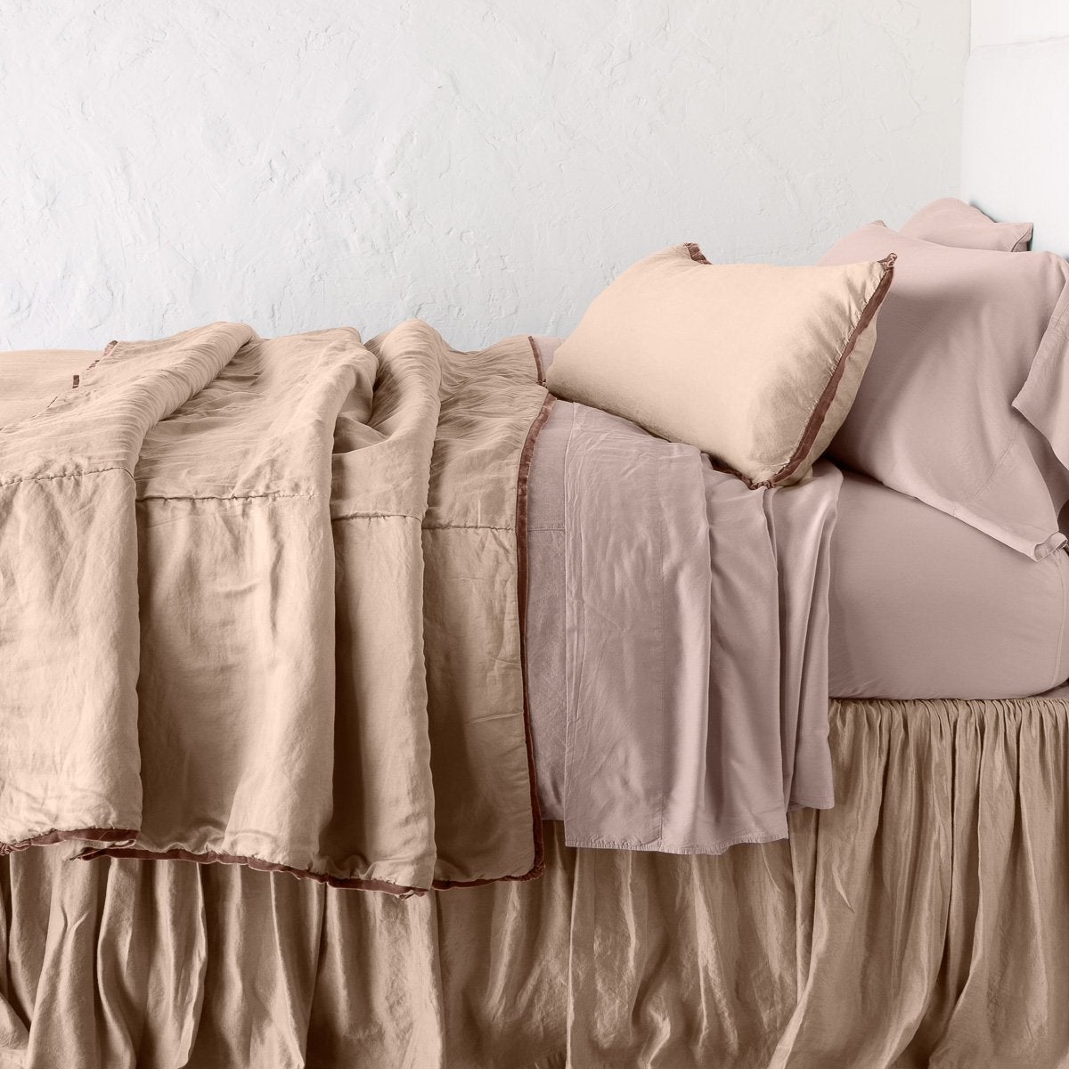 Rouge: throw blanket rumpled on a charmeuse monochromatic bed - side view.